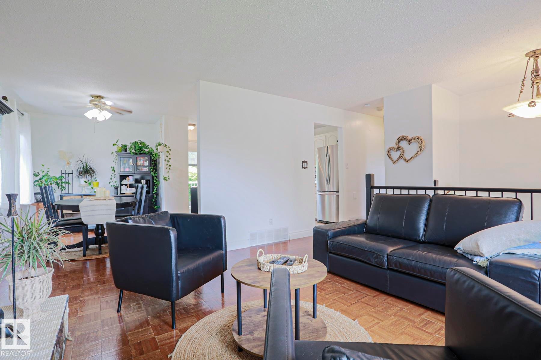 Spacious living area featuring wood-finish flooring, white walls, and an open concept layout - 2007 67 Street, Edmonton, AB