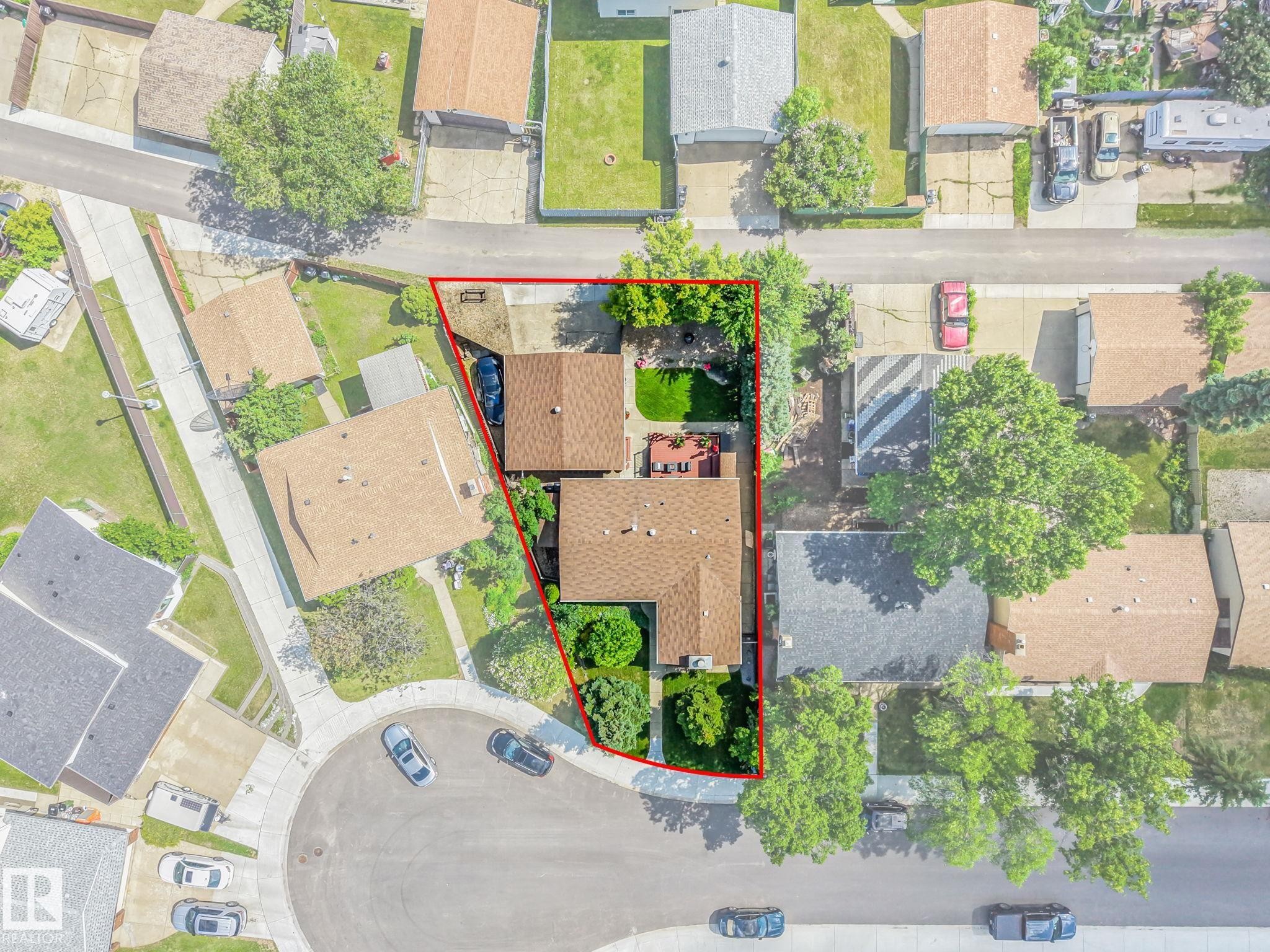 Aerial view highlighting the property with a red boundary, featuring two distinct structures with brown shingle roofing - 17237 104 Street, Edmonton, AB