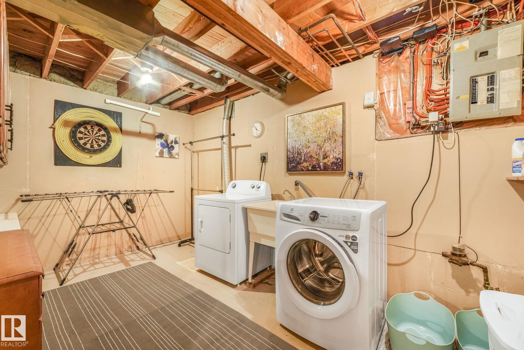 Laundry area featuring a utility sink, exposed ceiling joists, and a concrete floor - 17237 104 Street, Edmonton, AB