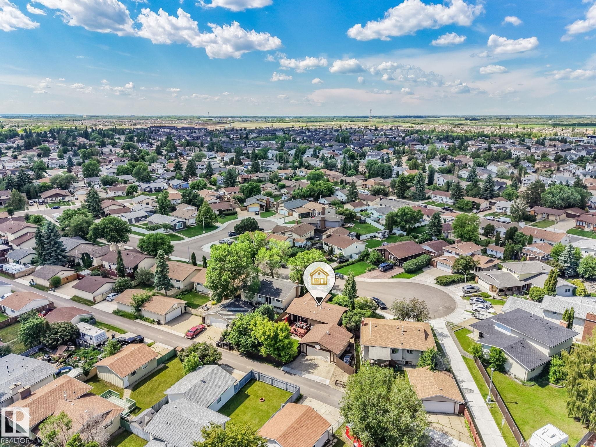 Aerial perspective showcasing a residential neighborhood with numerous detached homes, mature trees, and paved streets - 17237 104 Street, Edmonton, AB