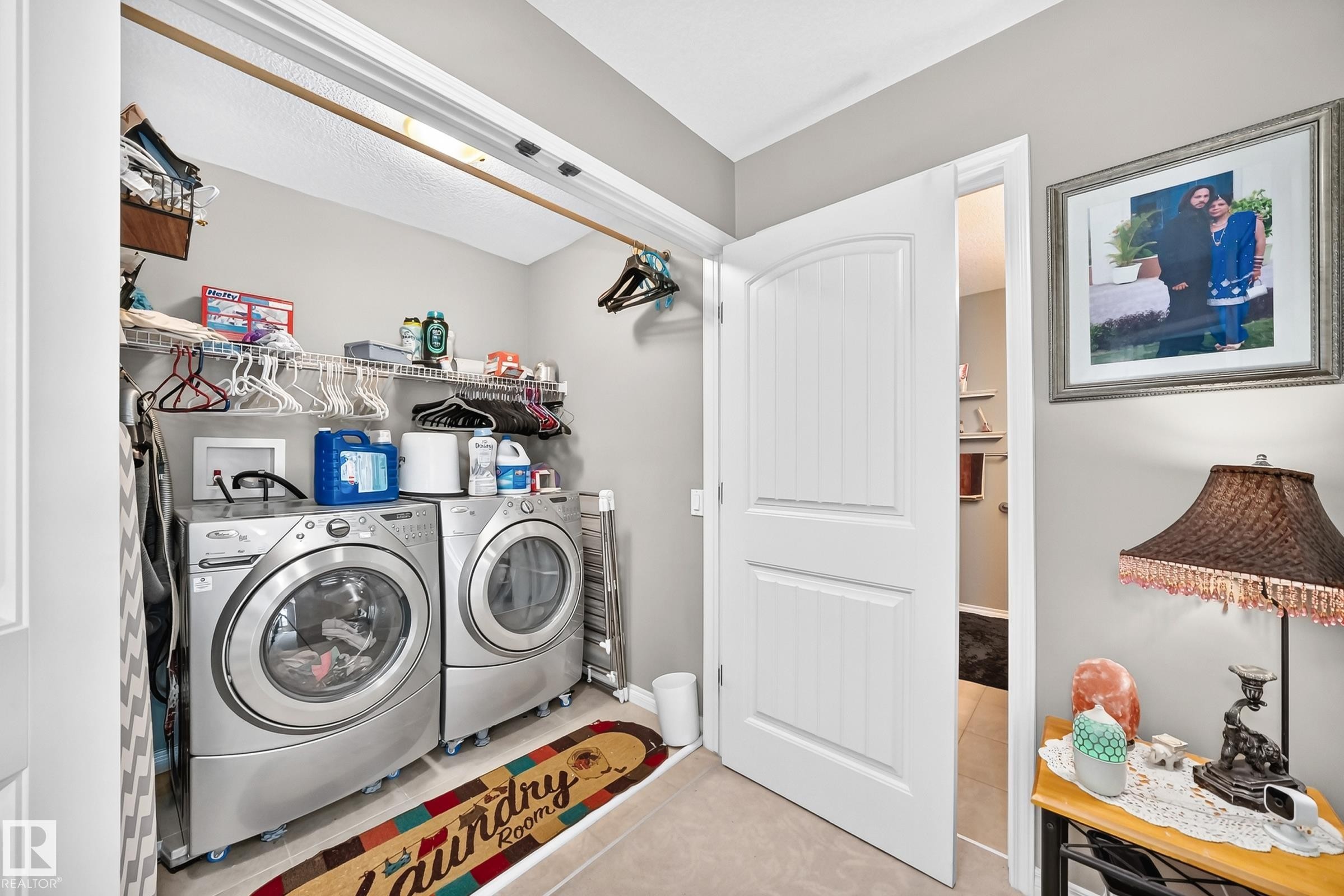 Dedicated laundry area featuring wire shelving, overhead storage, and tile flooring - 12410 171A Avenue, Edmonton, AB