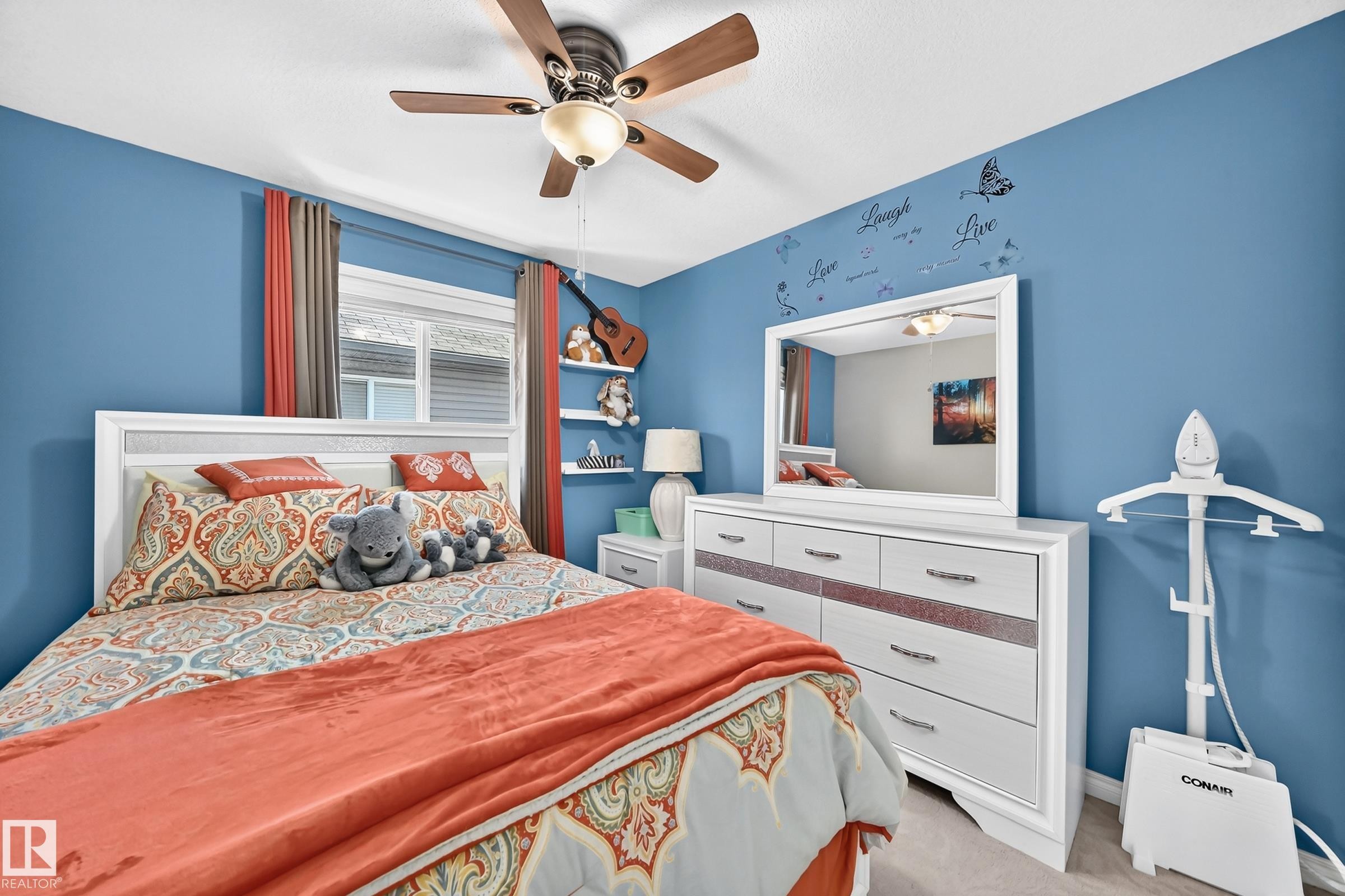 Bedroom featuring a white framed headboard, a ceiling fan with light fixture, and a window with blinds and drapes - 12410 171A Avenue, Edmonton, AB