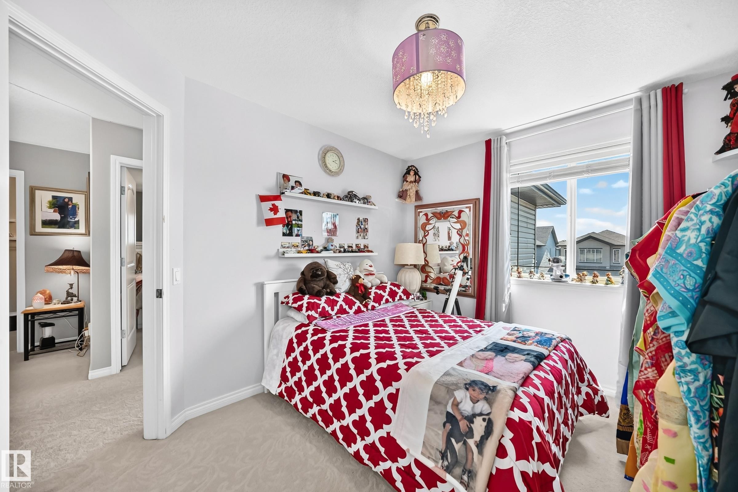Bedroom featuring a double-pane window, neutral wall paint, and light-toned carpet flooring - 12410 171A Avenue, Edmonton, AB