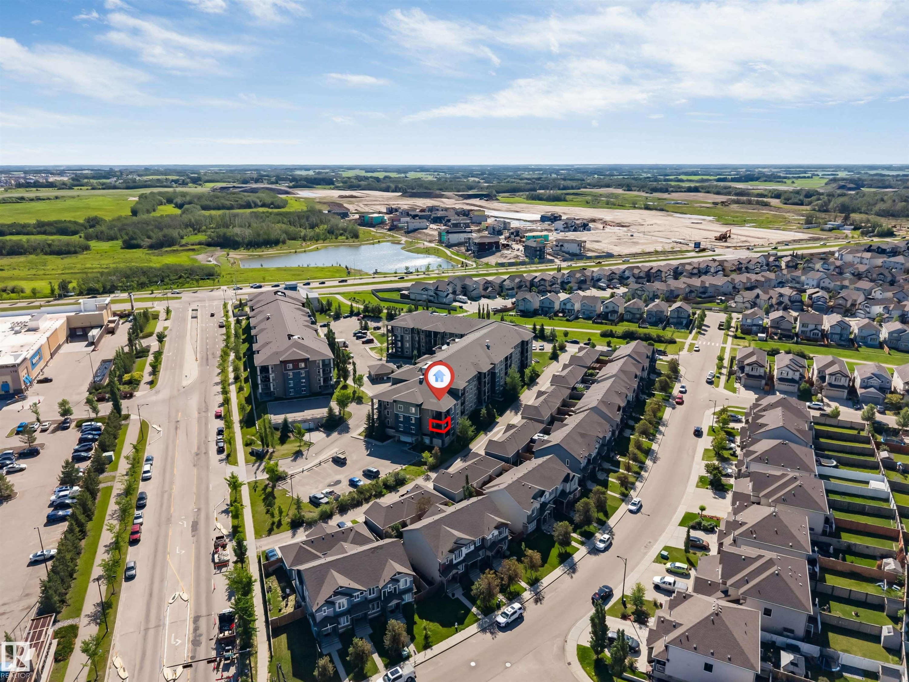 Aerial perspective showcasing the residential area with a lake visible in the distance - 225 111 Watt Common, Edmonton, AB