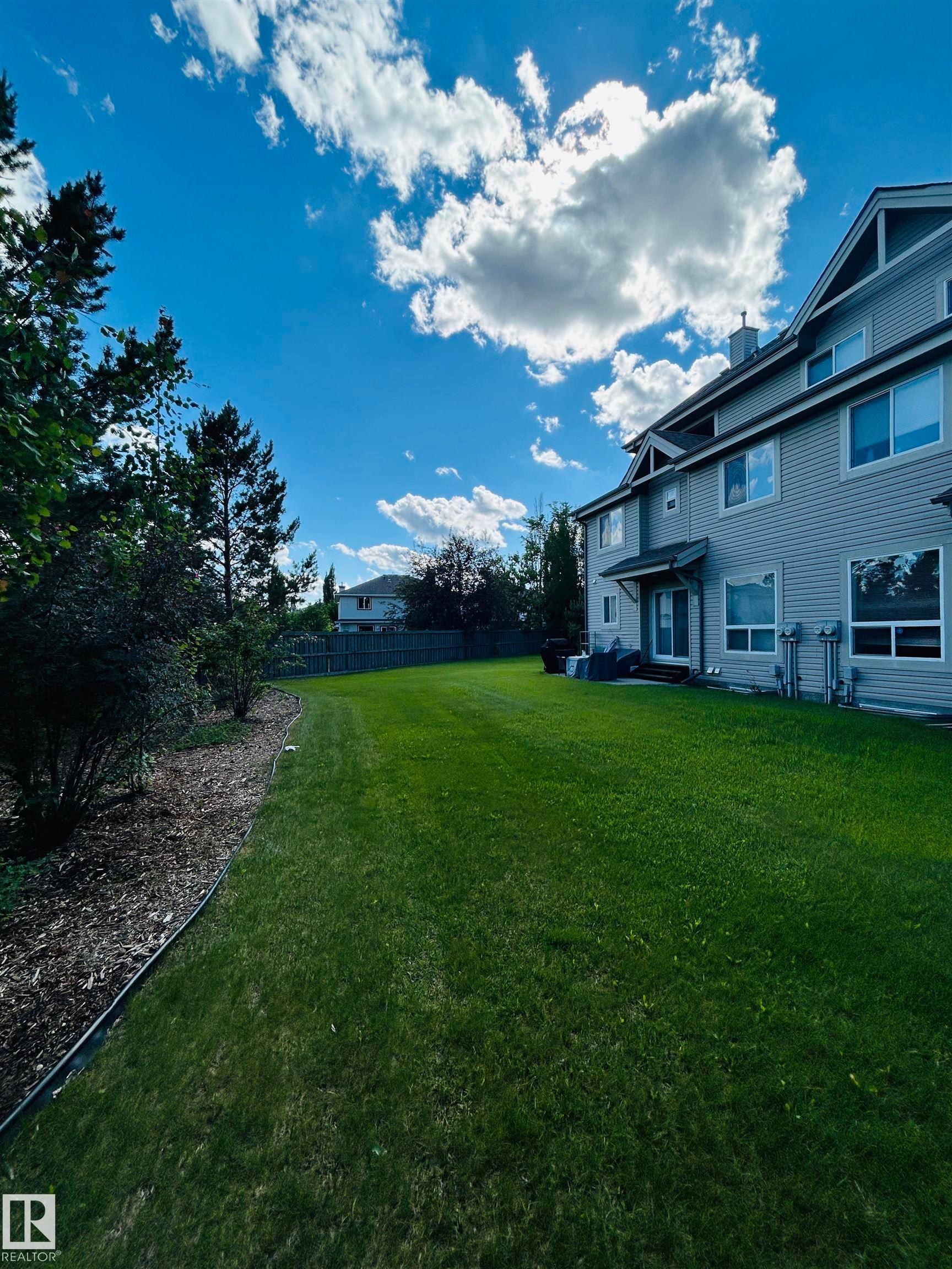 Expansive green lawn bordering a multi-story residence with horizontal siding - 89 12050 17 Avenue, Edmonton, AB