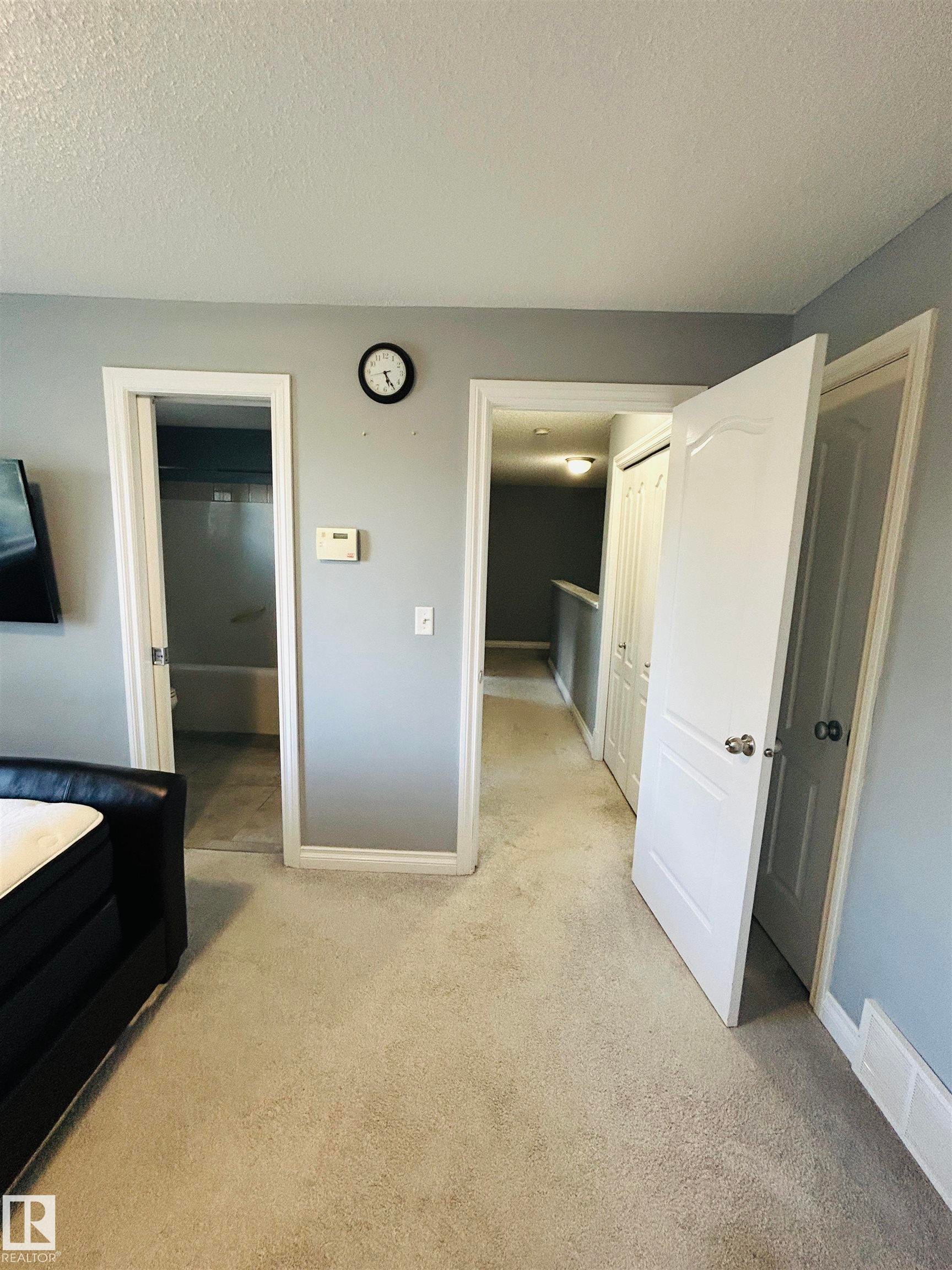 Neutral-toned carpeting extends throughout this interior space, featuring a light gray wall color and white trim - 89 12050 17 Avenue, Edmonton, AB