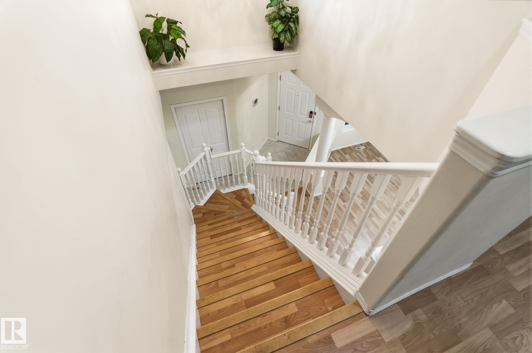 Staircase featuring wood-finish treads and white balusters - 1906 37B Av Nw, Edmonton, AB - Indoor Photo Showing Other Room