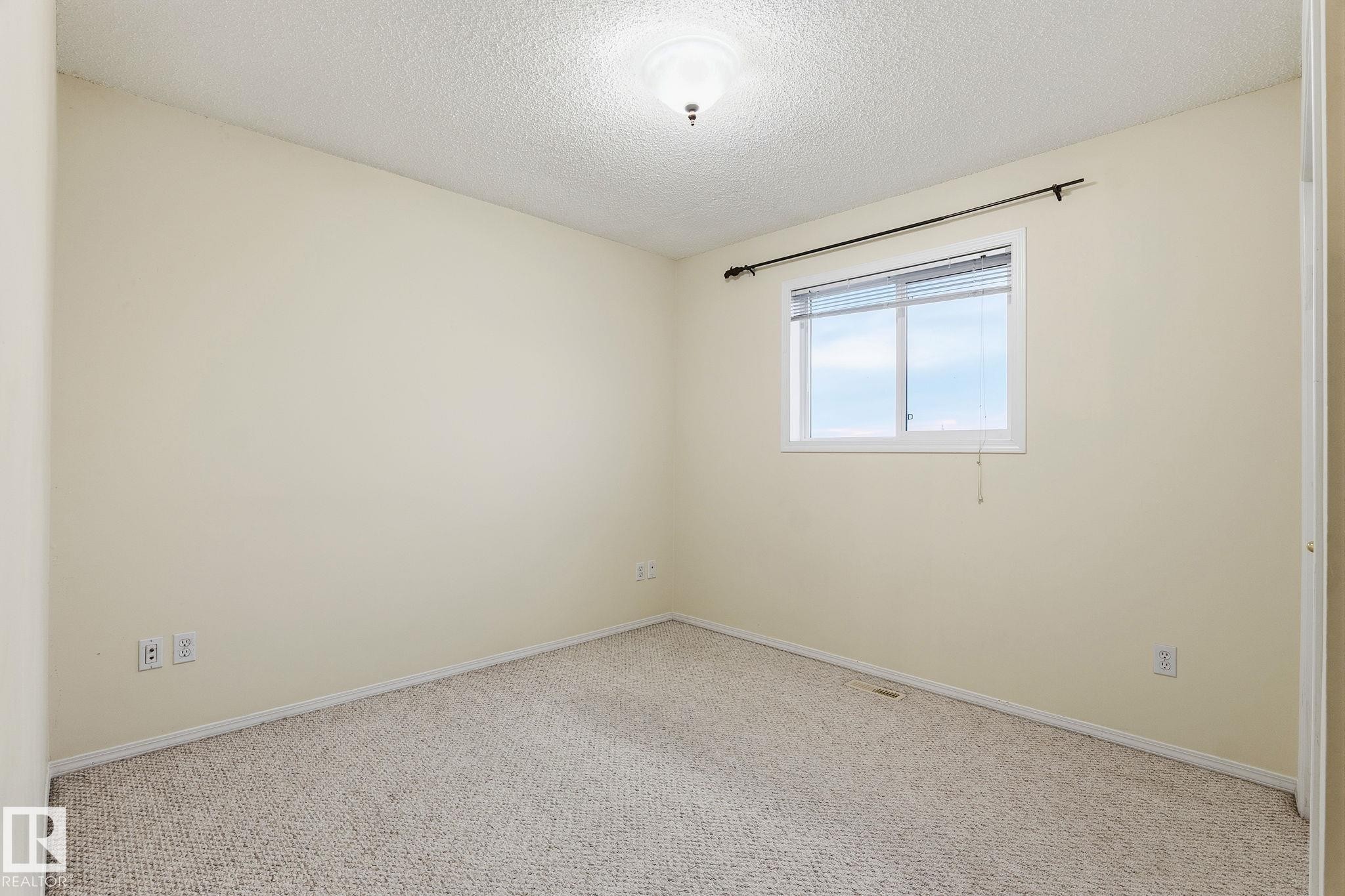 Neutral-toned walls complement the textured carpet flooring - 1906 37B Av Nw, Edmonton, AB - Indoor Photo Showing Other Room