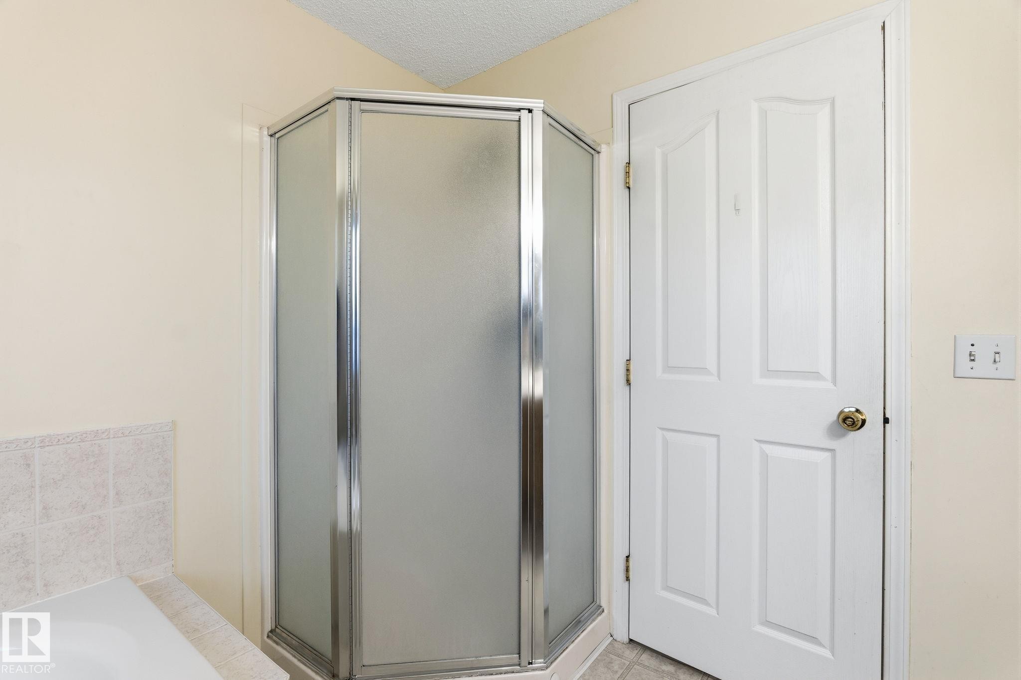 Corner shower enclosure with frosted glass panels and chrome framing - 1906 37B Av Nw, Edmonton, AB - Indoor
