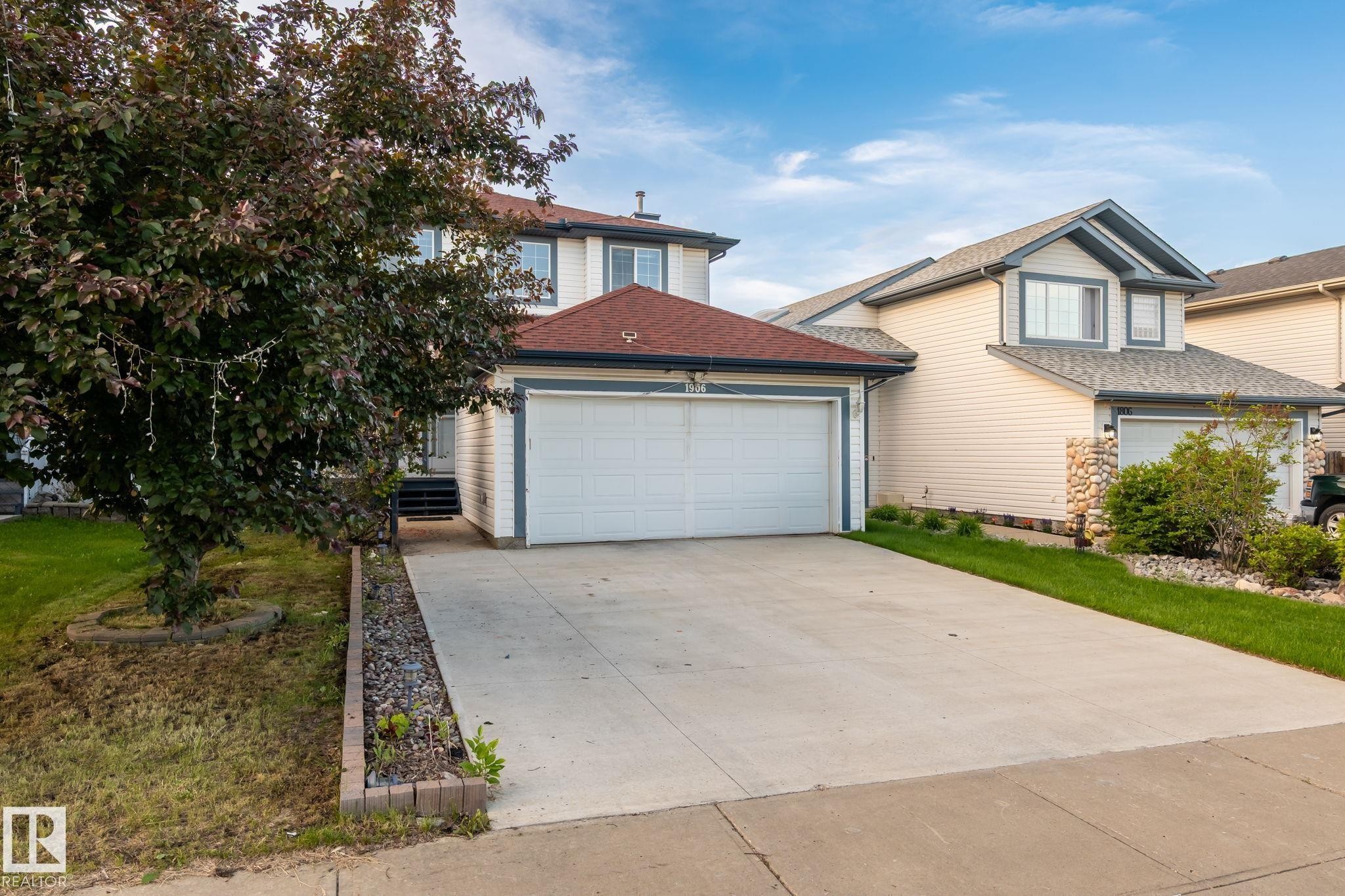 Two-story residence featuring light-colored siding and a red shingle roof - 1906 37B Av Nw, Edmonton, AB - Outdoor