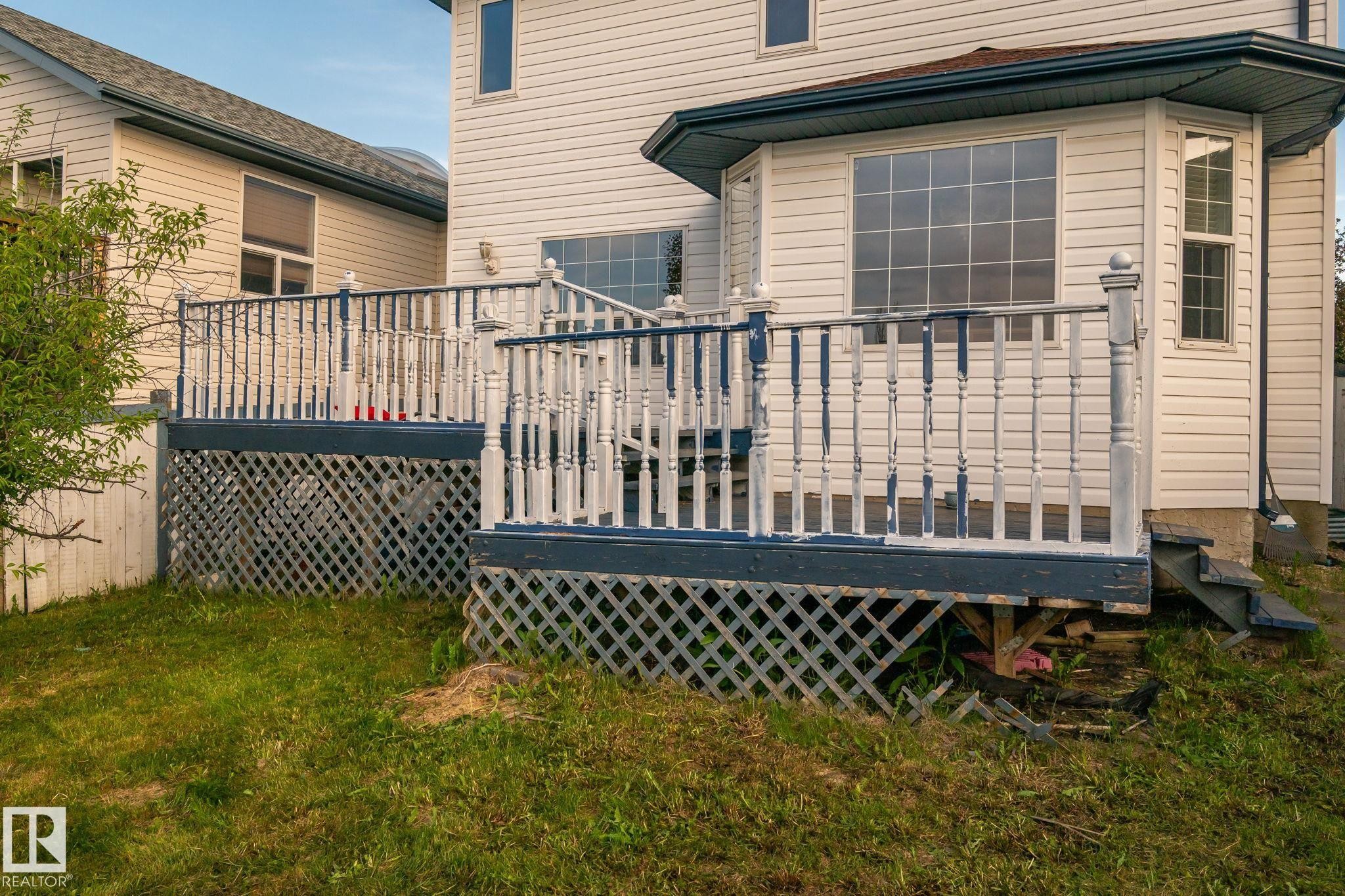 Rear exterior featuring white vinyl siding and a multi-level wooden deck - 1906 37B Av Nw, Edmonton, AB - Outdoor With Deck Patio Veranda With Exterior