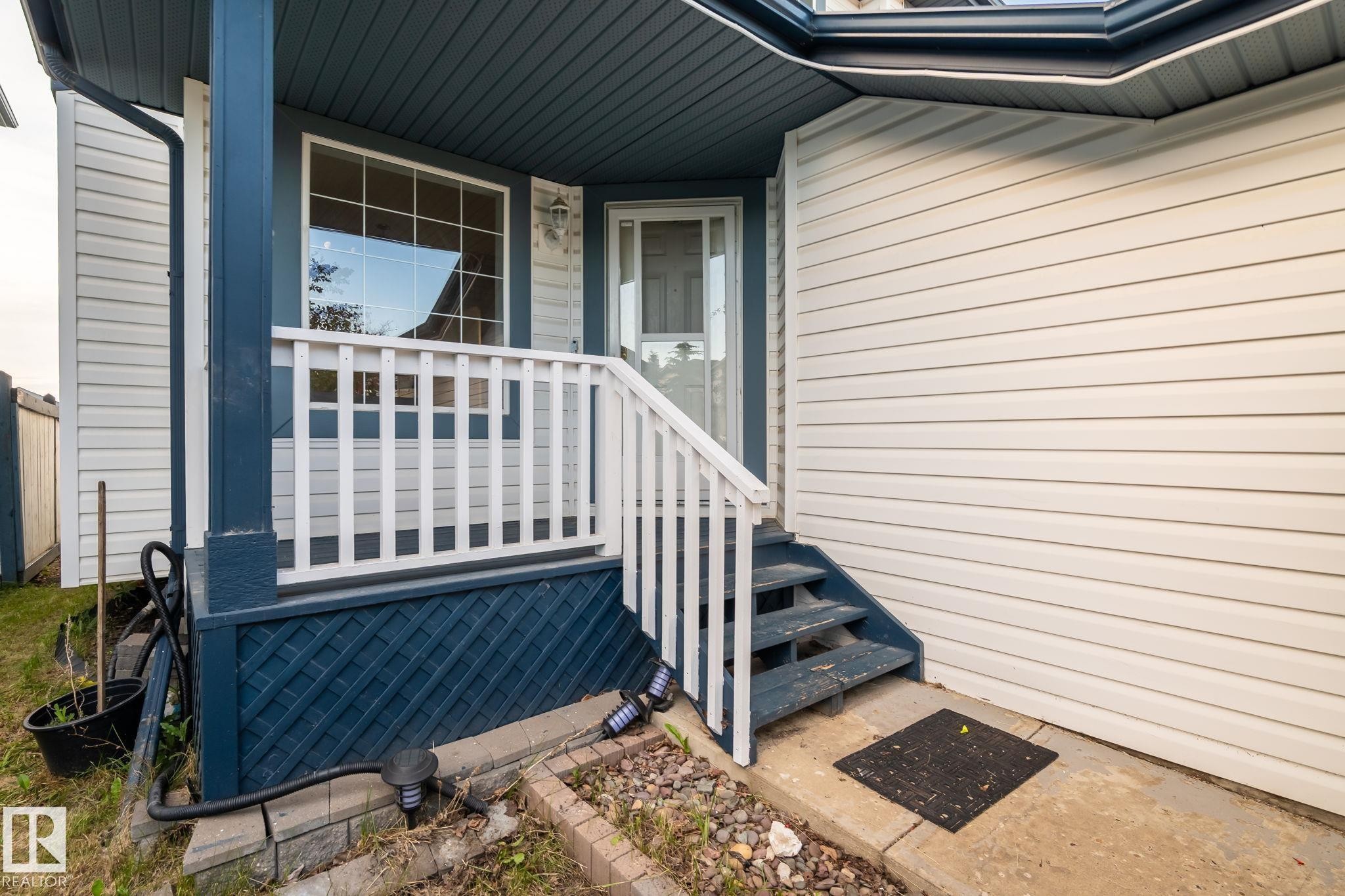 Front entry featuring white siding and a covered porch - 1906 37B Av Nw, Edmonton, AB - Outdoor With Deck Patio Veranda With Exterior