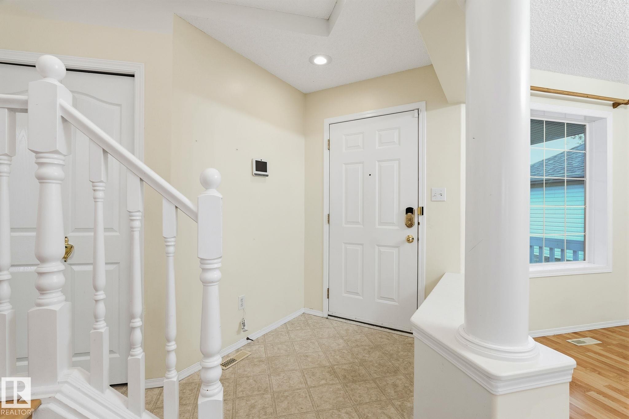 Entryway featuring a paneled door with brass hardware, tile flooring, and a recessed ceiling light - 1906 37B Av Nw, Edmonton, AB - Indoor Photo Showing Other Room