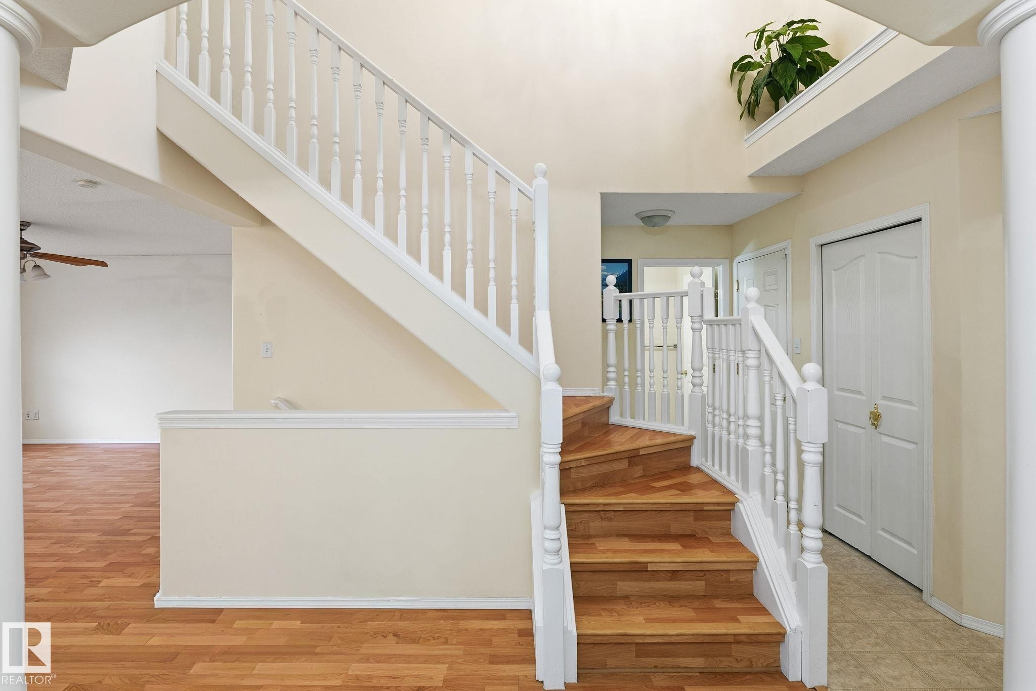 Grand central staircase featuring wood-finish treads and white balusters - 1906 37B Av Nw, Edmonton, AB - Indoor Photo Showing Other Room