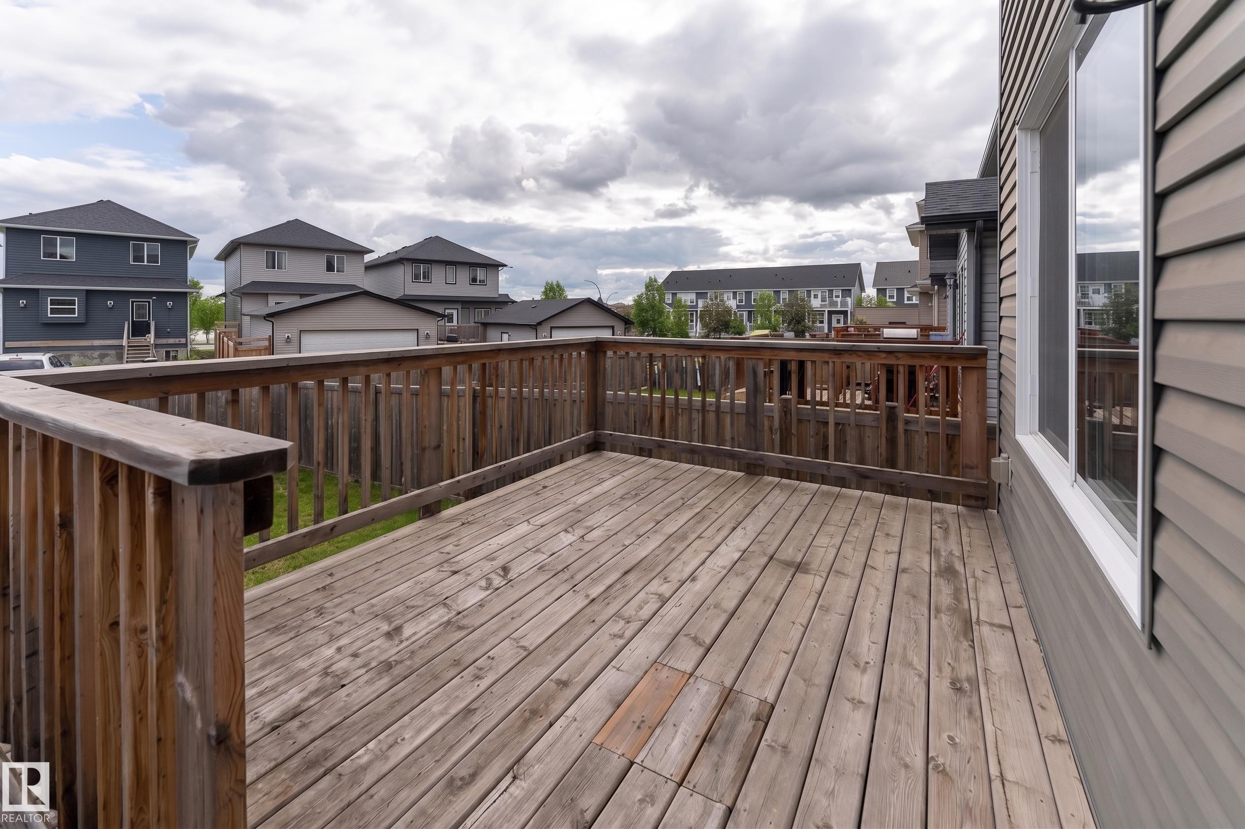 Spacious outdoor deck featuring natural wood decking and matching wood railings - 191 Reed Place, Leduc, AB - Outdoor With Exterior