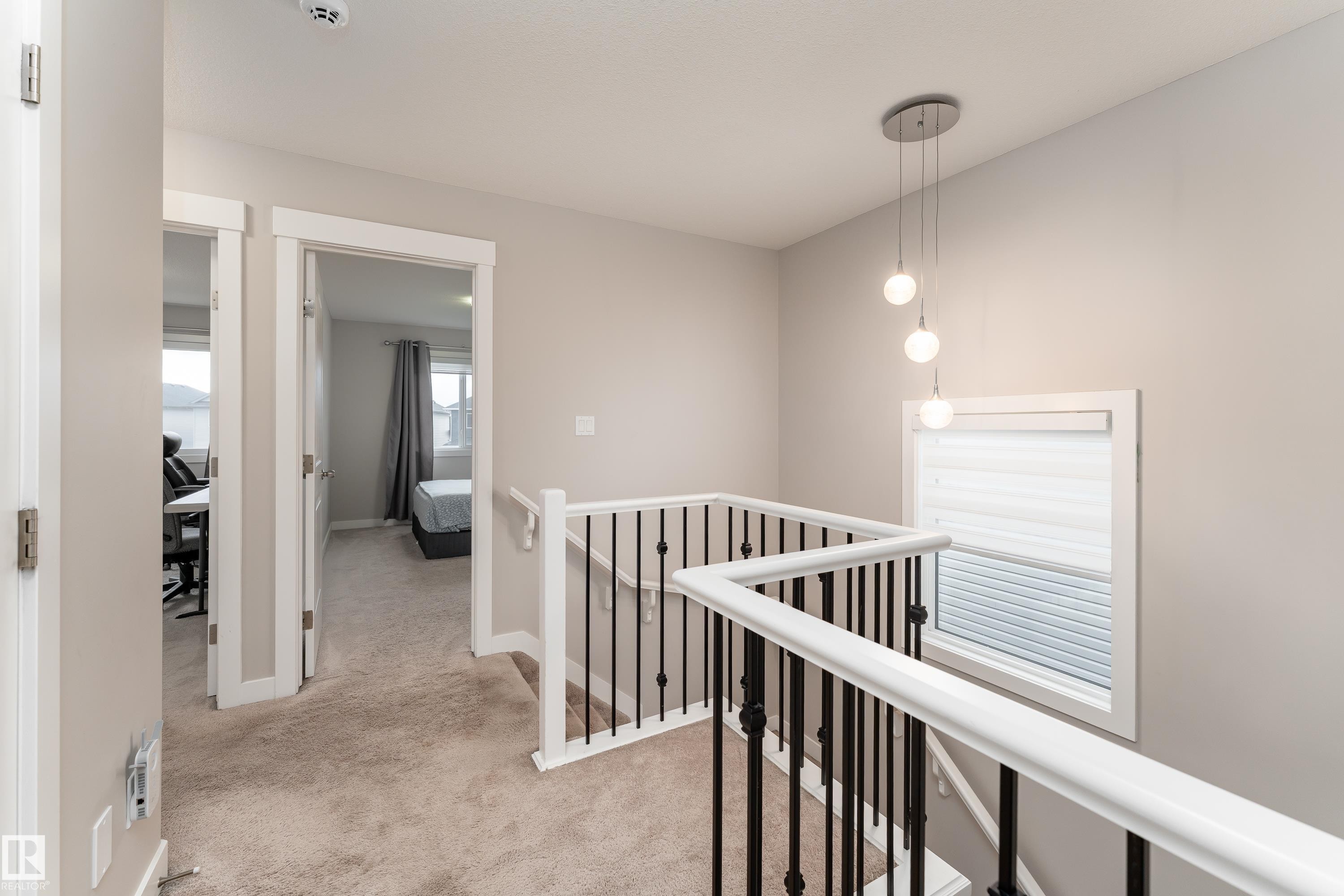 Upper-level hallway featuring neutral carpeting, white trim, and light gray wall paint - 191 Reed Place, Leduc, AB - Indoor