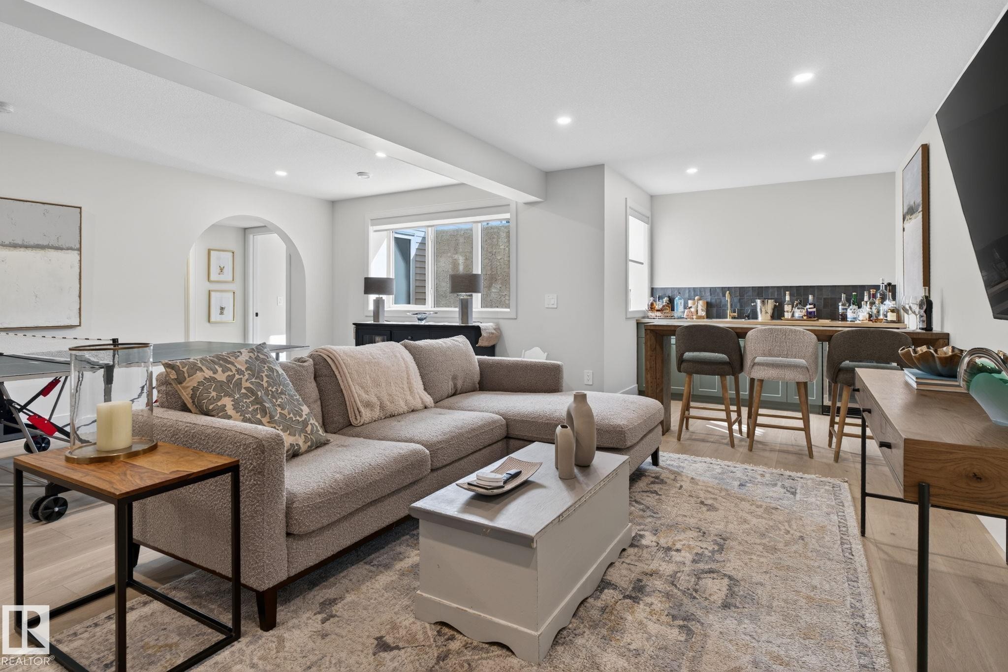 Open-concept living area with light wood-finish flooring, recessed lighting, and an arched doorway - 14 Jane Point(E), St. Albert, AB