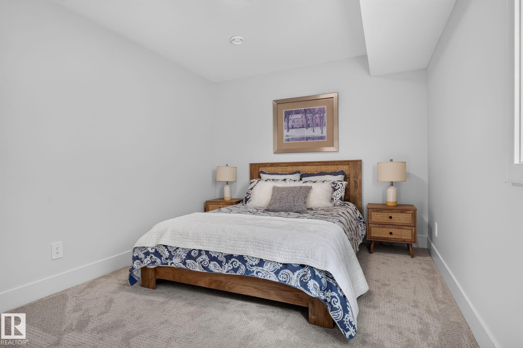 Spacious room featuring light-toned carpeting, ample natural light from a side window, and recessed ceiling lighting - 14 Jane Point(E), St. Albert, AB