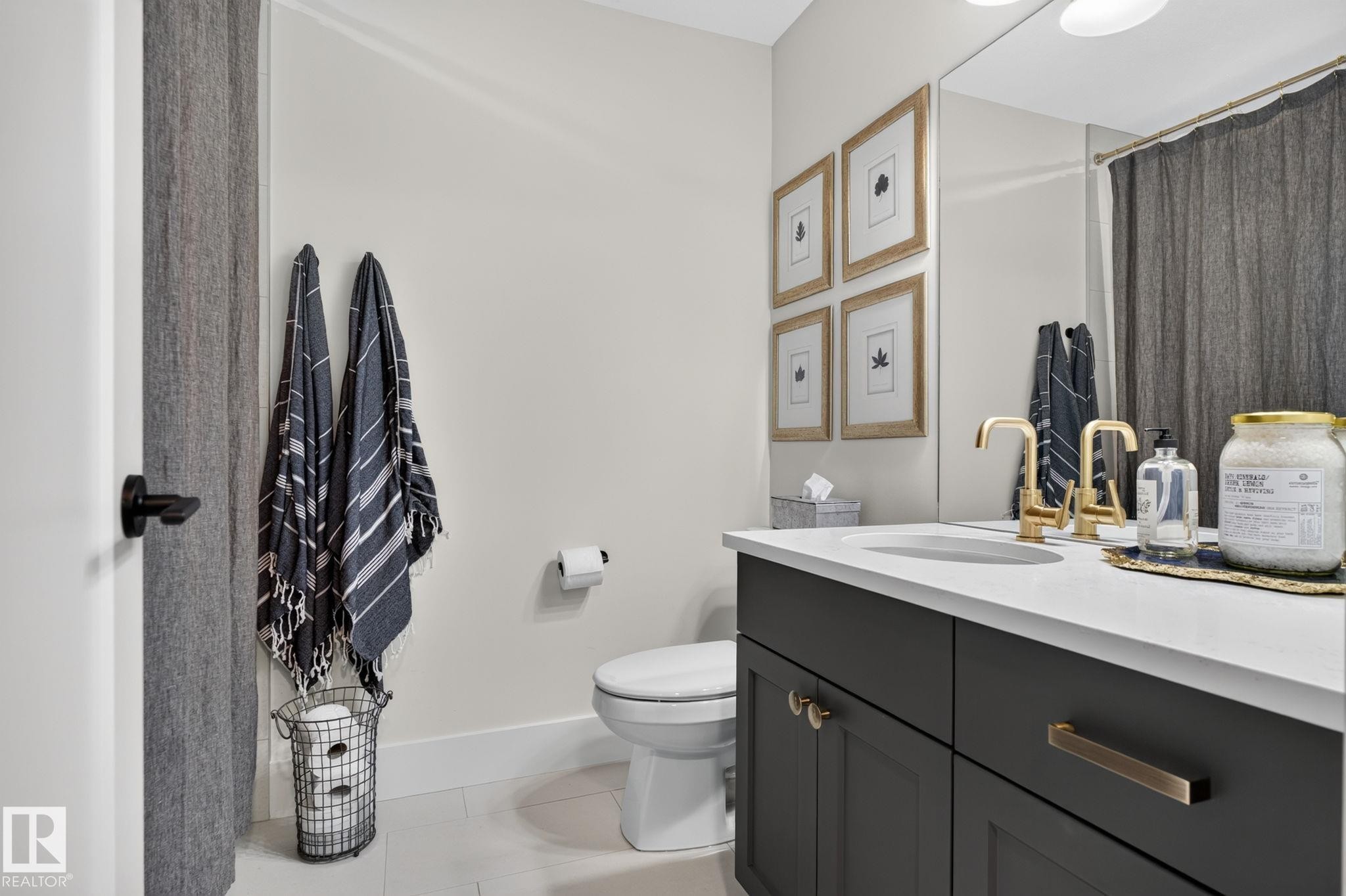 White vanity countertop with an integrated sink and brass-finish fixtures - 14 Jane Point(E), St. Albert, AB