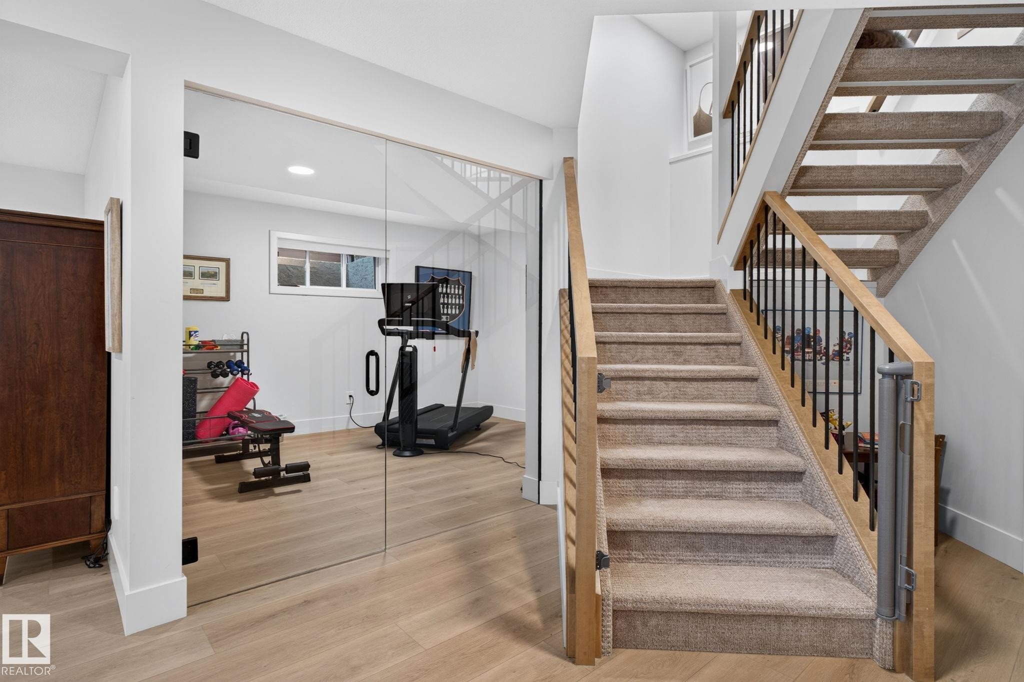 Carpeted staircase with light wood handrails and black metal balusters - 14 Jane Point(E), St. Albert, AB
