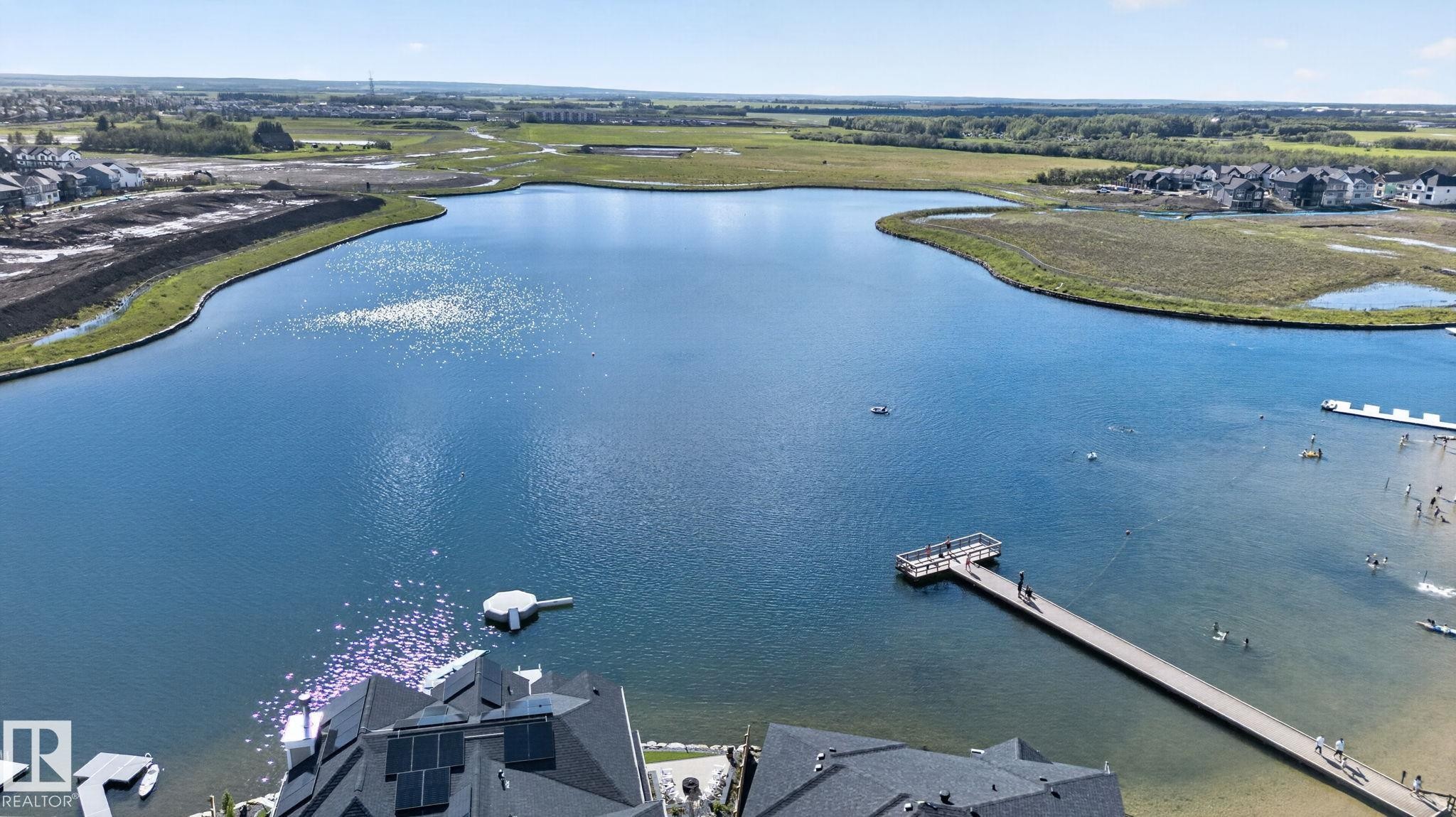 Expansive lakefront property featuring a long pier, a floating dock, and shoreline access - 14 Jane Point(E), St. Albert, AB