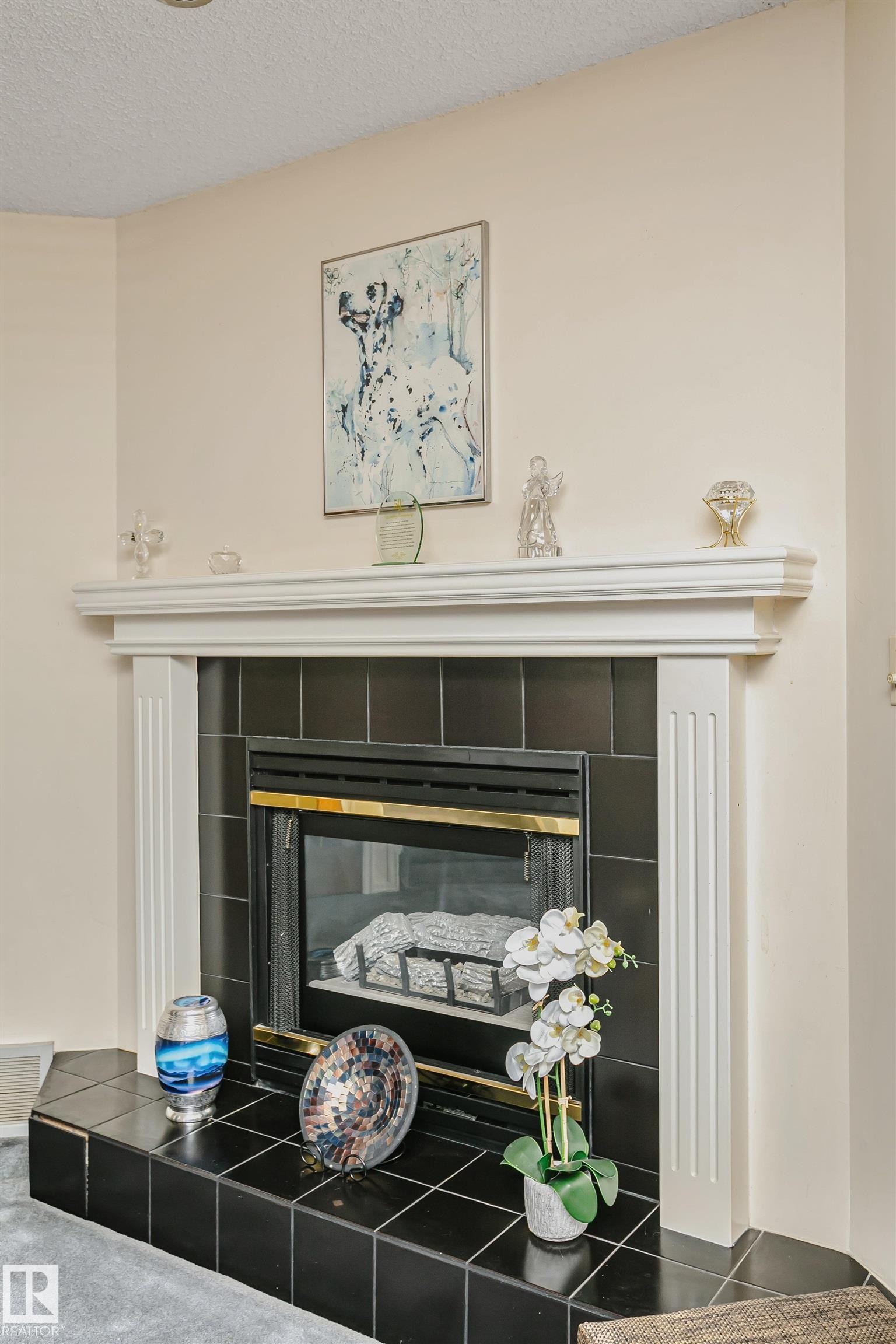 Fireplace with a black tile surround and hearth, featuring a white mantle with fluted pilasters - 1612 80A Street, Edmonton, AB