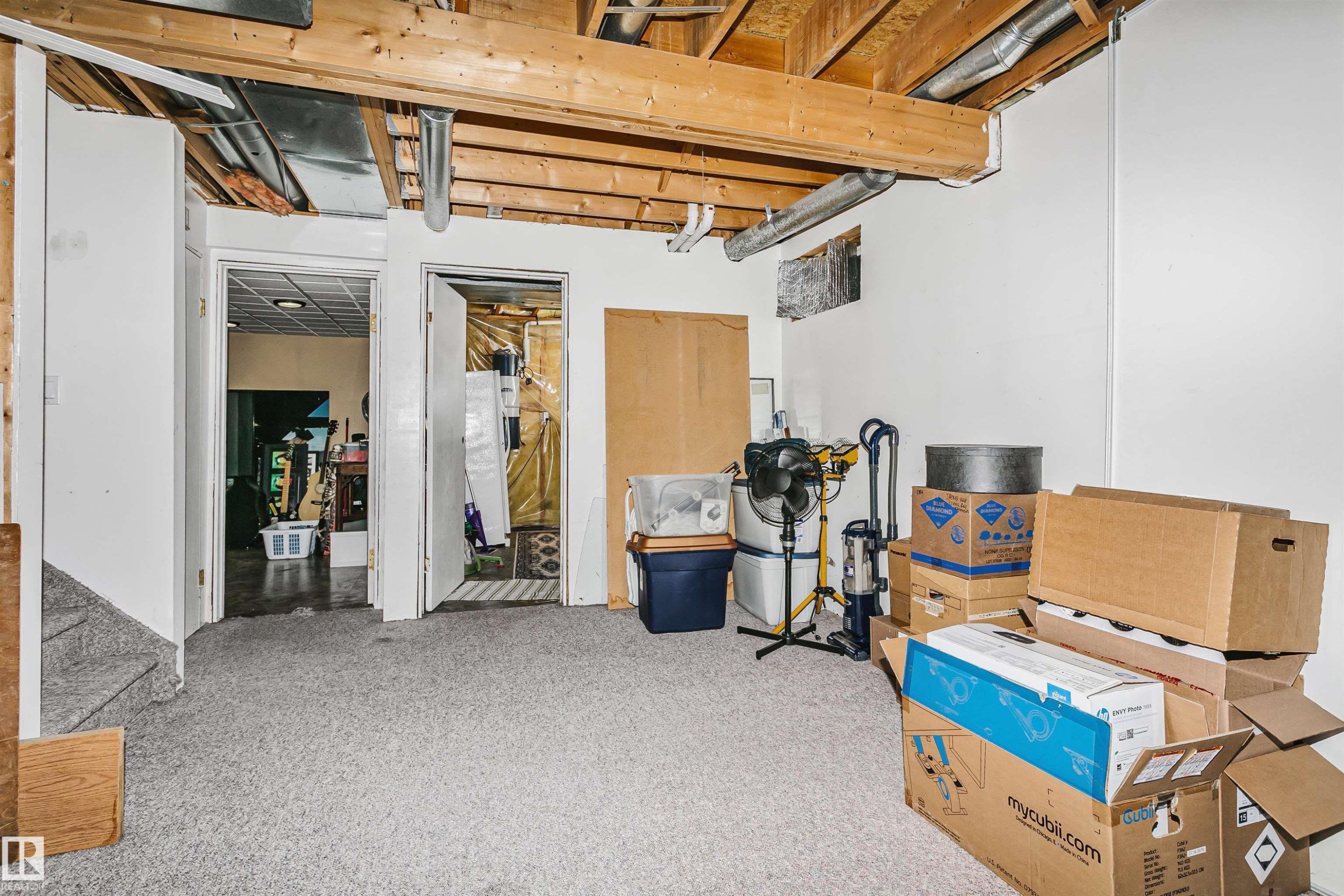 Utility space featuring exposed ceiling joists and ductwork, carpeted flooring, and white painted walls - 1612 80A Street, Edmonton, AB