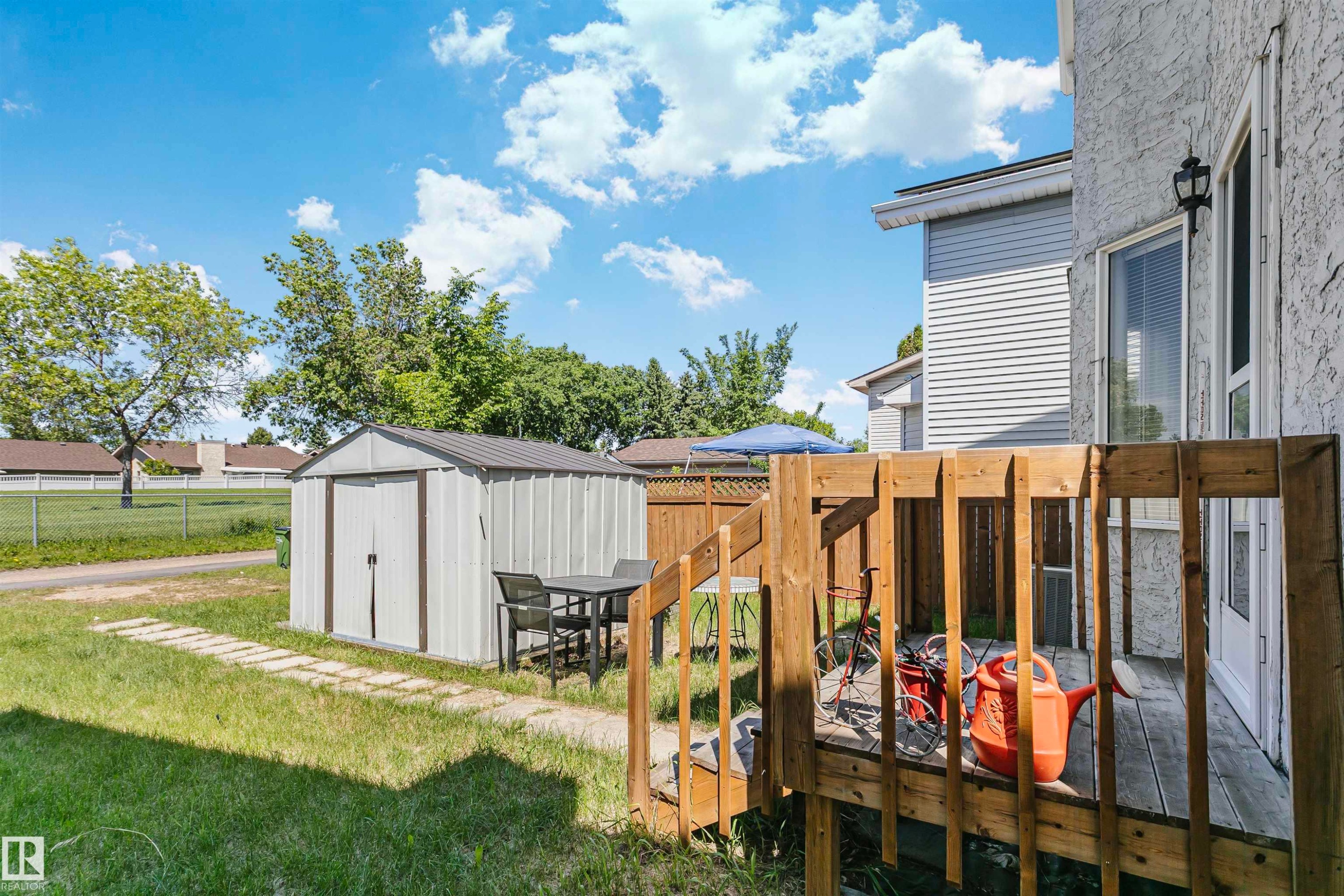 Ground-level wooden deck with a privacy fence - 1612 80A Street, Edmonton, AB