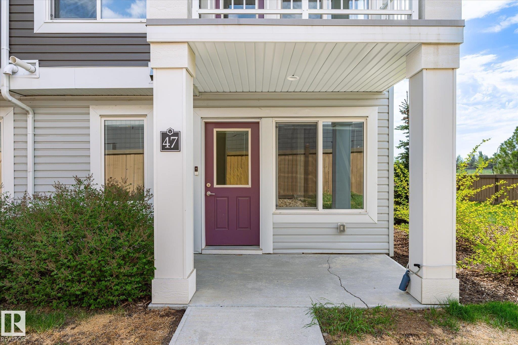 Entryway featuring a covered porch, purple paneled door with glass insert, and side-lite window - 47 330 Bulyea Road, Edmonton, AB - Outdoor With Balcony With Exterior