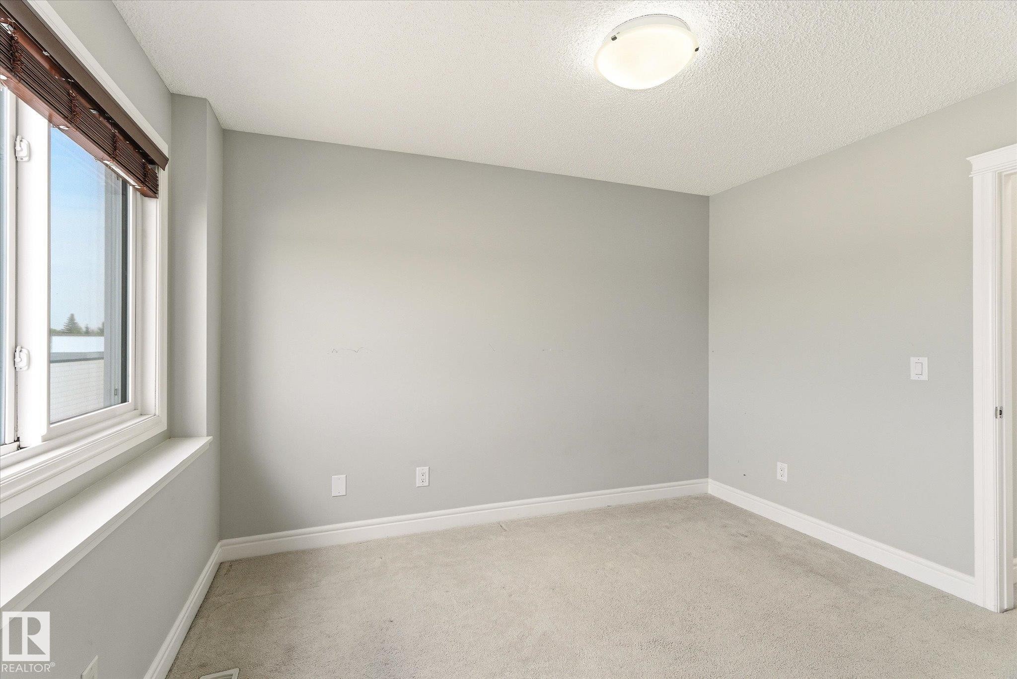 Room featuring a window with wooden blinds, light gray wall paint, white baseboards, and neutral carpet flooring - 47 330 Bulyea Road, Edmonton, AB - Indoor Photo Showing Other Room