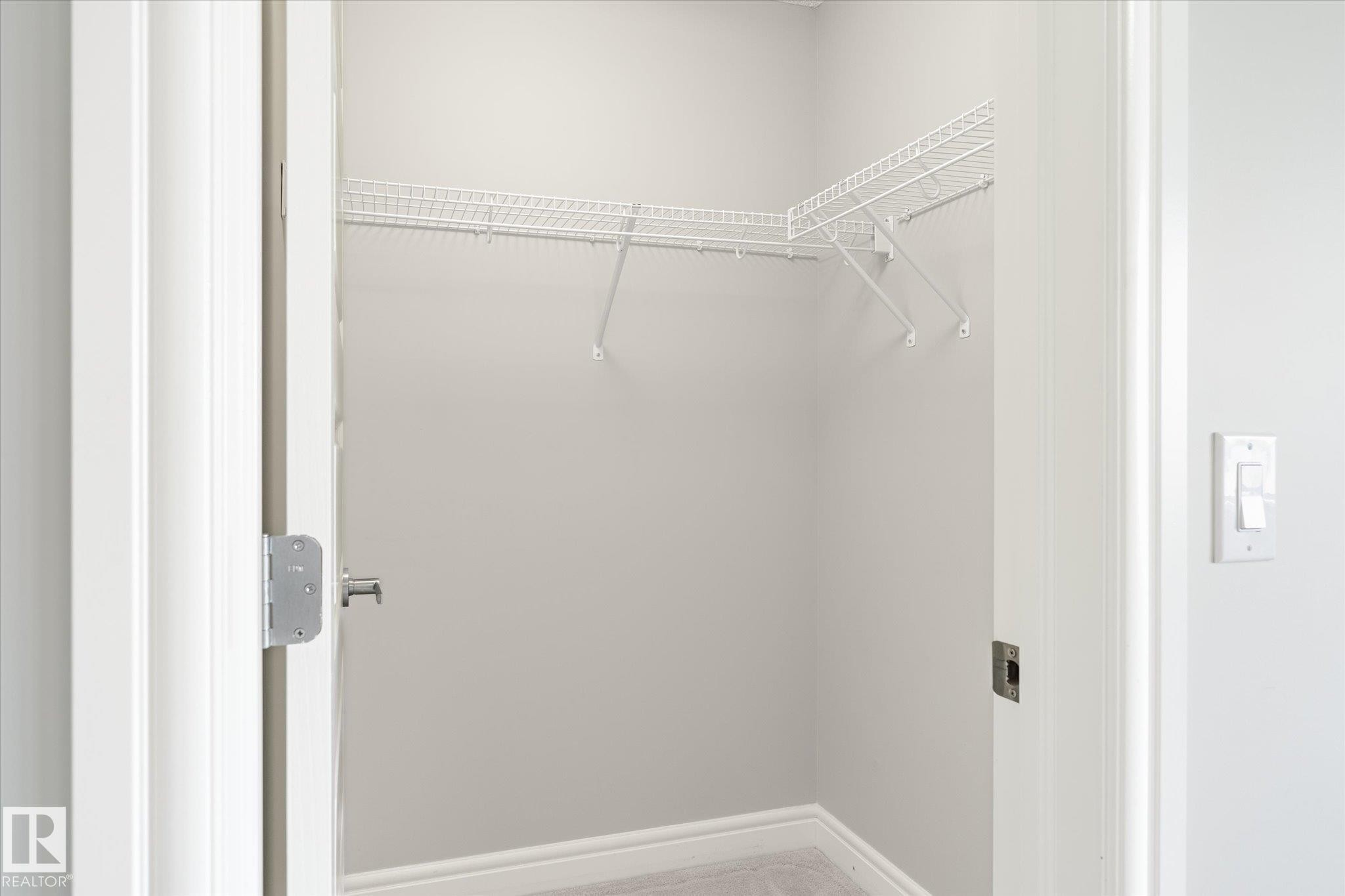 Utility closet featuring wire shelving, light gray wall paint, white trim, and light-colored flooring - 47 330 Bulyea Road, Edmonton, AB - Indoor With Storage