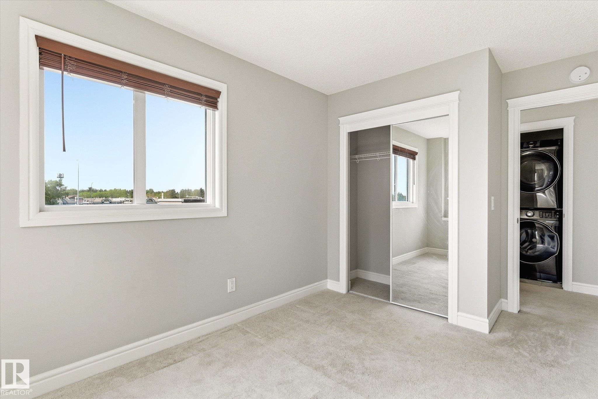 Room featuring light-toned carpeting and a double window with wood-tone blinds - 47 330 Bulyea Road, Edmonton, AB - Indoor Photo Showing Other Room