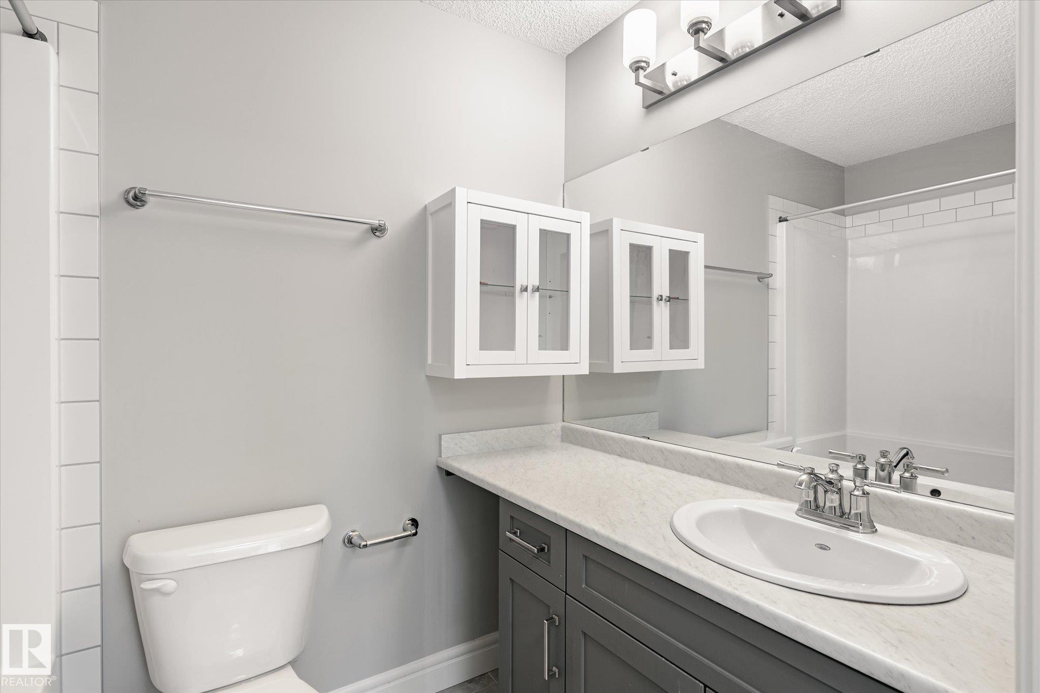 Bathroom featuring a vanity with a light-toned countertop, an integrated sink, and a chrome faucet - 47 330 Bulyea Road, Edmonton, AB - Indoor Photo Showing Bathroom