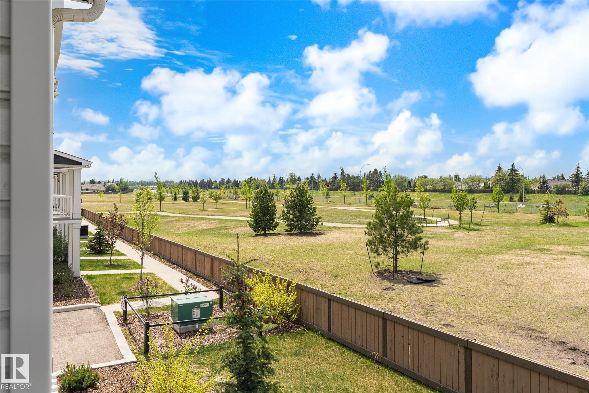 Expansive green space featuring mature trees and a walking path bordered by a wood privacy fence - 47 330 Bulyea Road, Edmonton, AB - Outdoor With View