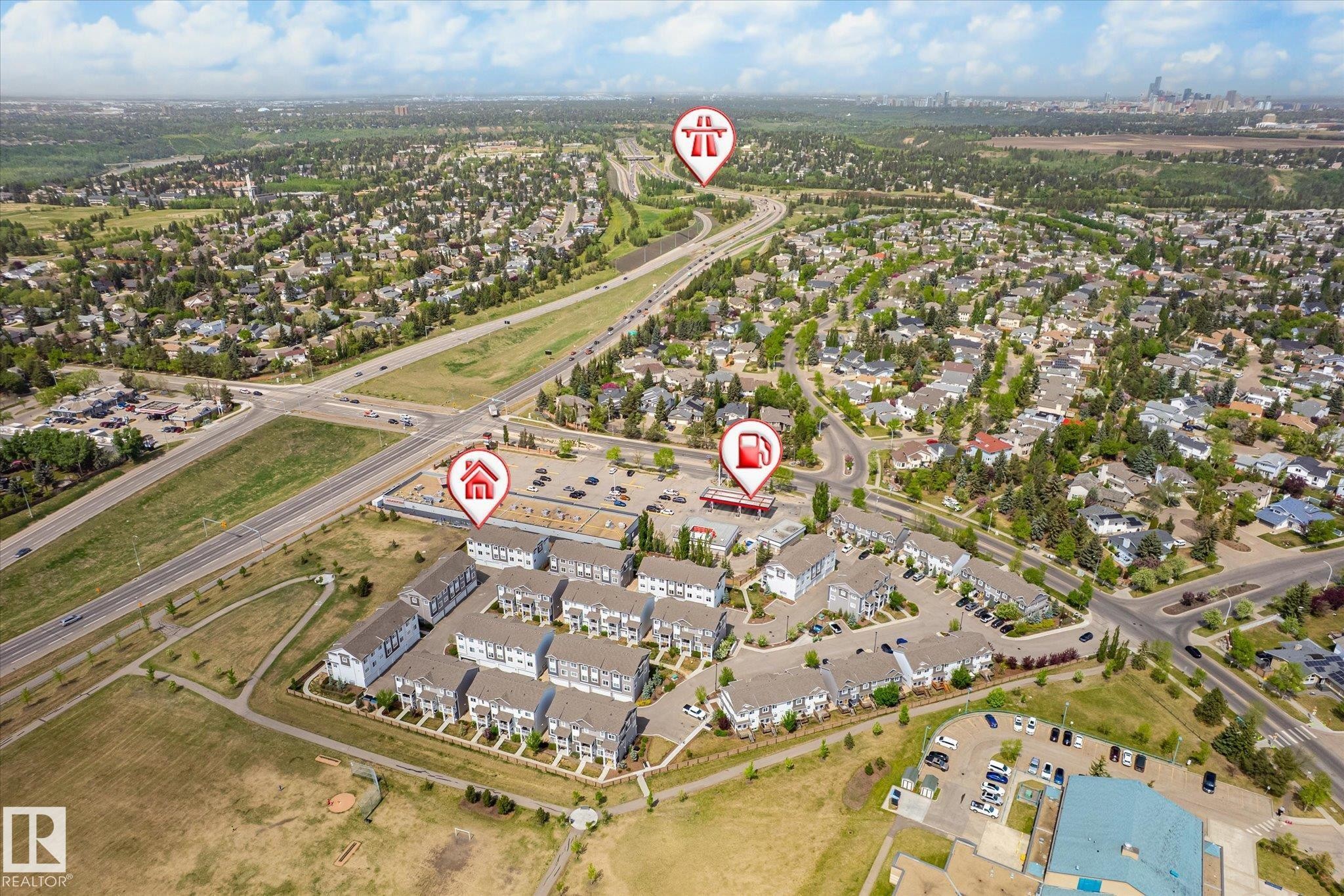 Aerial perspective showcasing a residential development with numerous multi-story townhomes, surrounded by established neighborhoods and green spaces - 47 330 Bulyea Road, Edmonton, AB - Outdoor With View