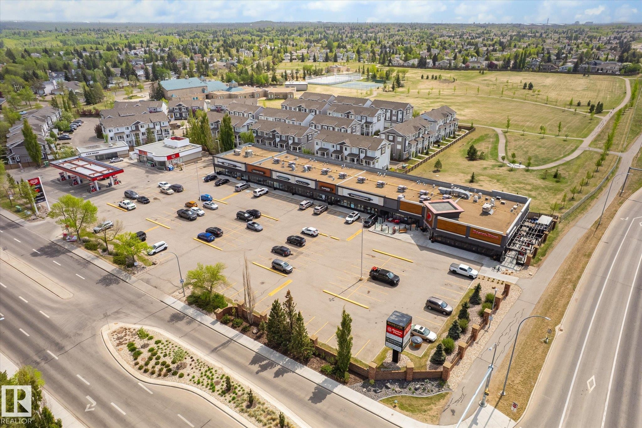 Commercial retail strip center with ample surface parking, multiple storefronts, and direct street access - 47 330 Bulyea Road, Edmonton, AB - Outdoor With View