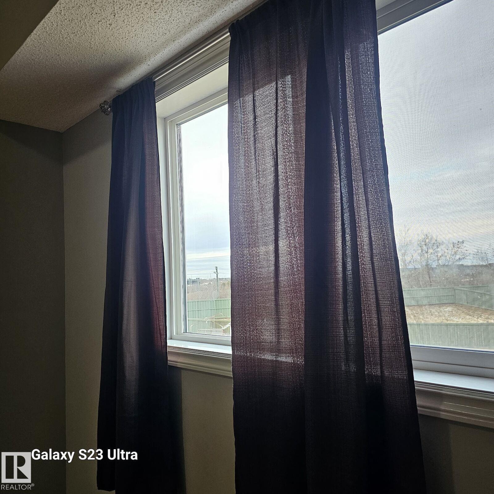 Window with white trim and dark fabric curtains - 99 13825 155 Avenue, Edmonton, AB