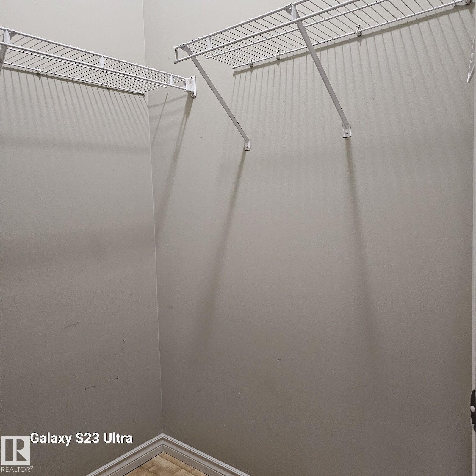 Walk-in closet featuring light gray walls, white wire shelving, and trim - 99 13825 155 Avenue, Edmonton, AB