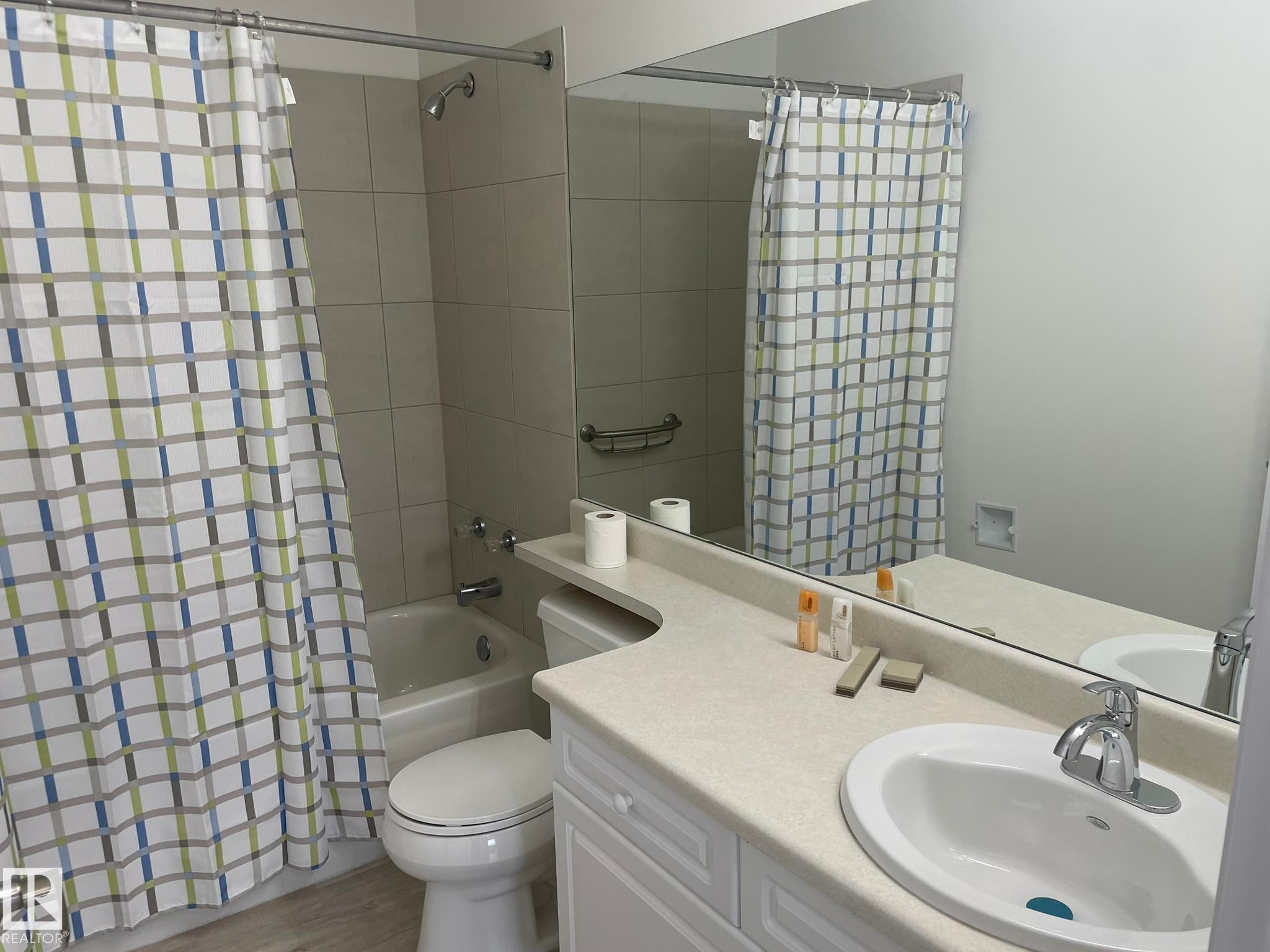 Full bathroom featuring a white porcelain tub and shower combination with light-toned tile surround - 2 1295 Carter Crest Road, Edmonton, AB - Indoor Photo Showing Bathroom