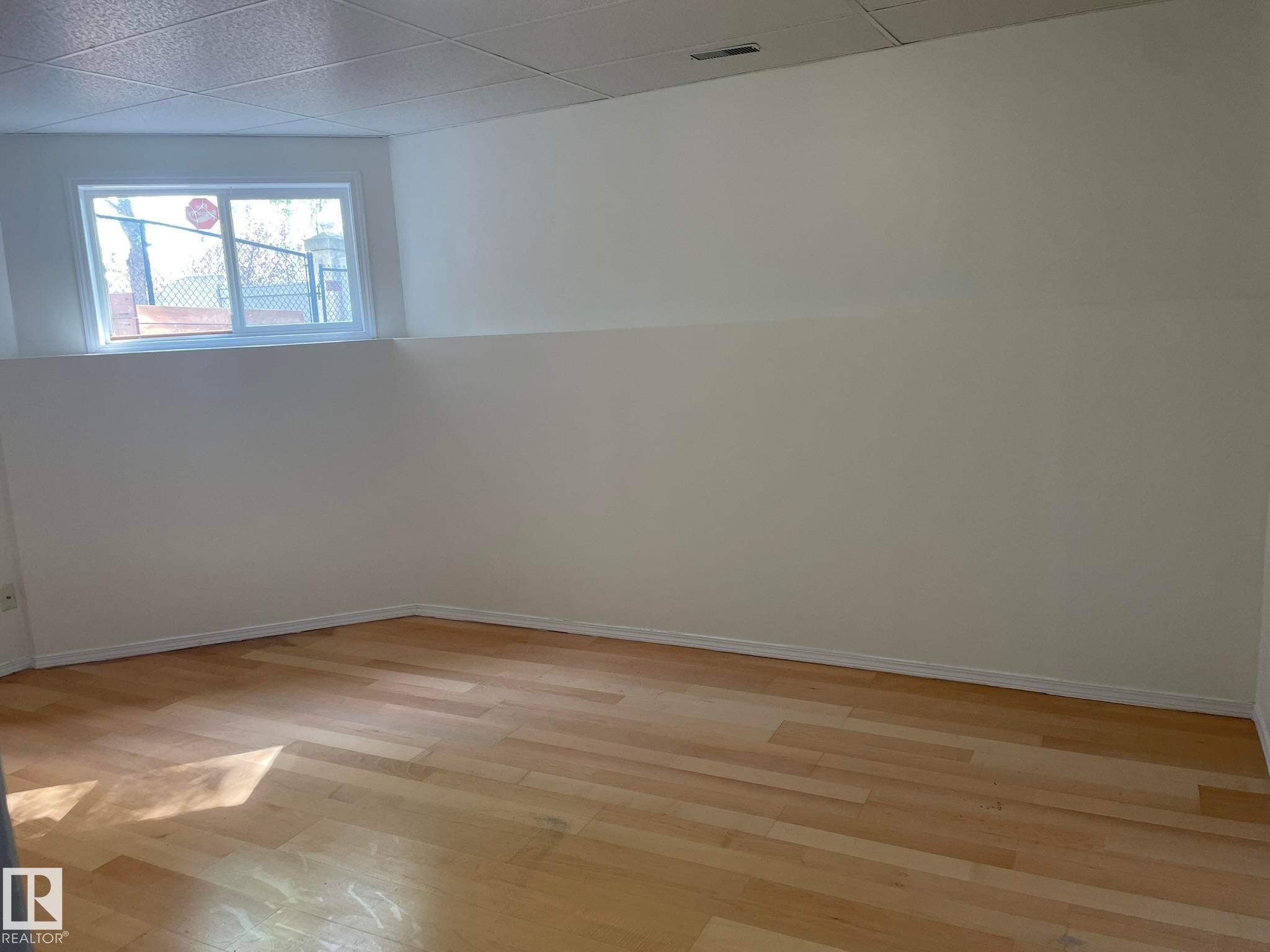 Room featuring wood-finish flooring, neutral painted walls, and a drop ceiling - 2 1295 Carter Crest Road, Edmonton, AB - Indoor Photo Showing Other Room