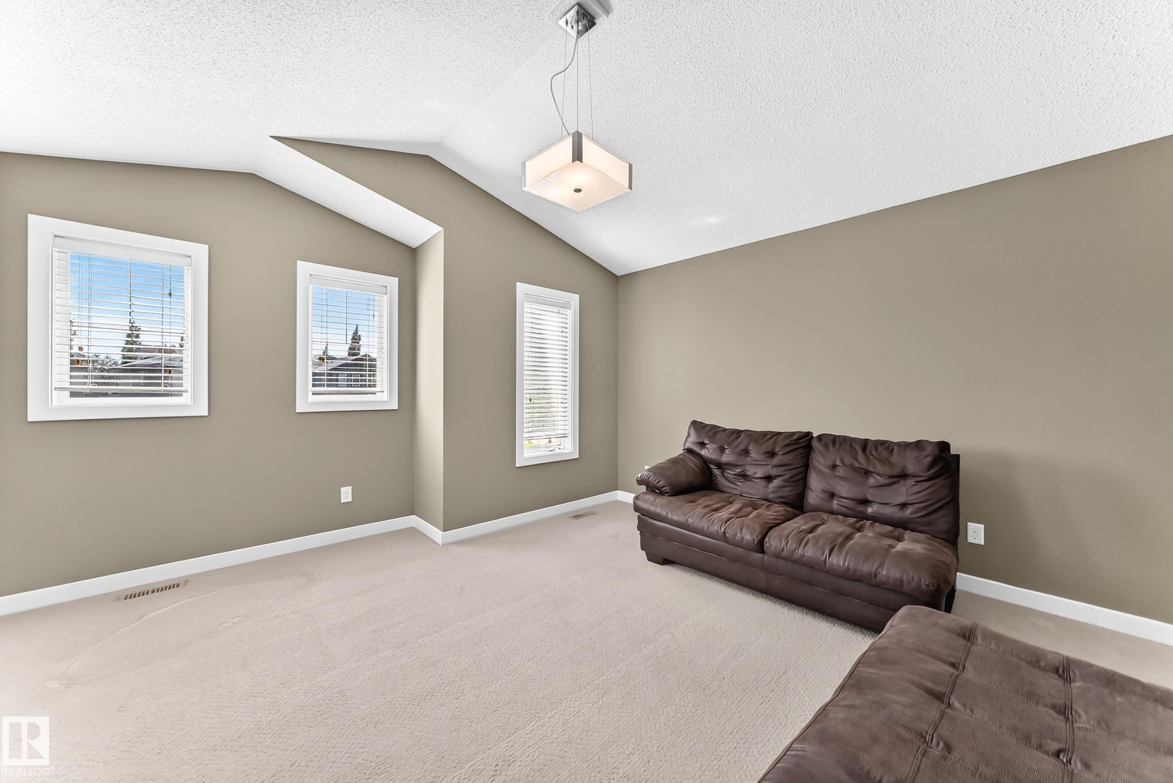 Carpeted room with vaulted ceilings and neutral-toned walls - 3433 Goodridge Link Link, Edmonton, AB