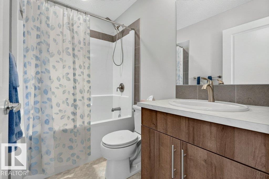 Bathroom featuring a vanity with a light-colored countertop, an undermount sink, and a brushed nickel faucet - 2116 Maple Road, Edmonton, AB