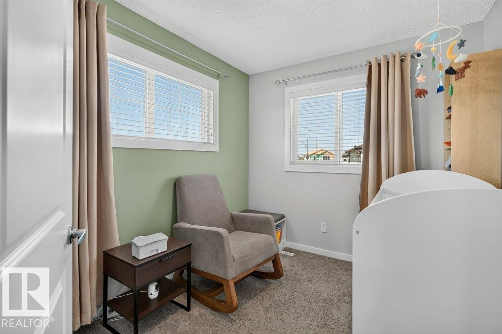 Room featuring two windows with blinds, carpeted flooring, and a two-tone wall treatment - 2116 Maple Road, Edmonton, AB