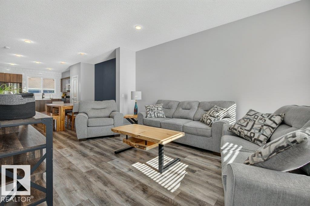 Open-concept living area featuring wood-finish flooring and recessed lighting - 2116 Maple Road, Edmonton, AB