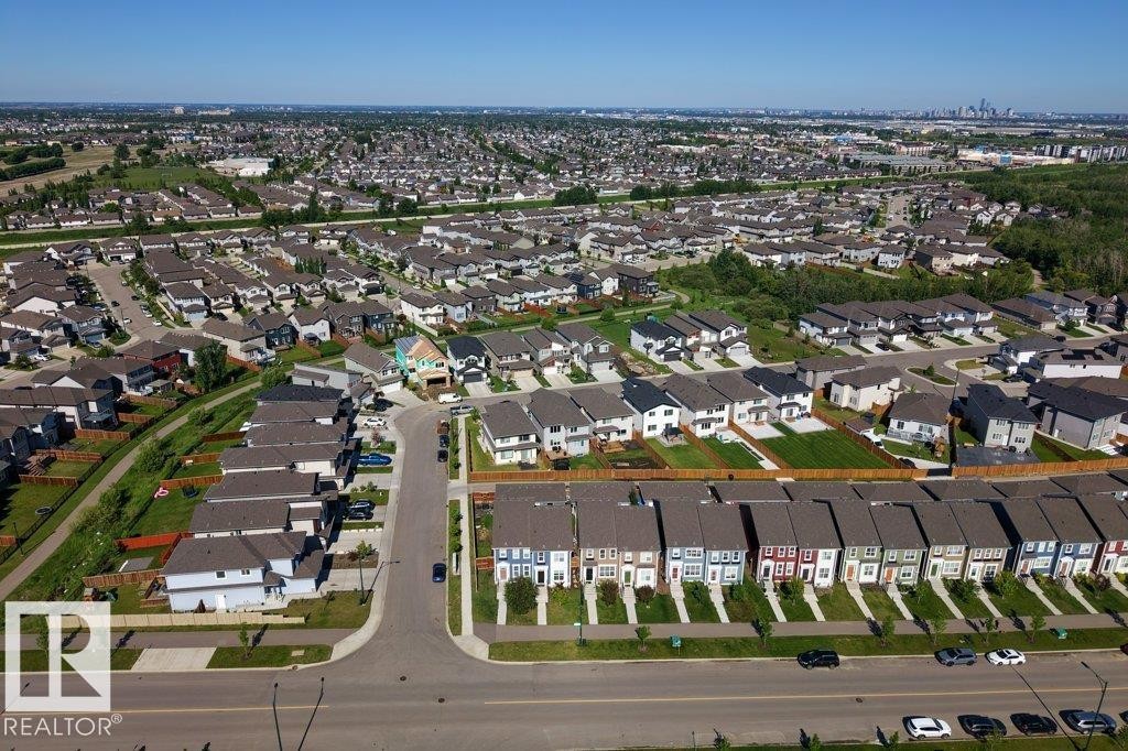 Aerial perspective of a developed residential area featuring a variety of housing styles, including detached homes and rows of townhomes - 2116 Maple Road, Edmonton, AB