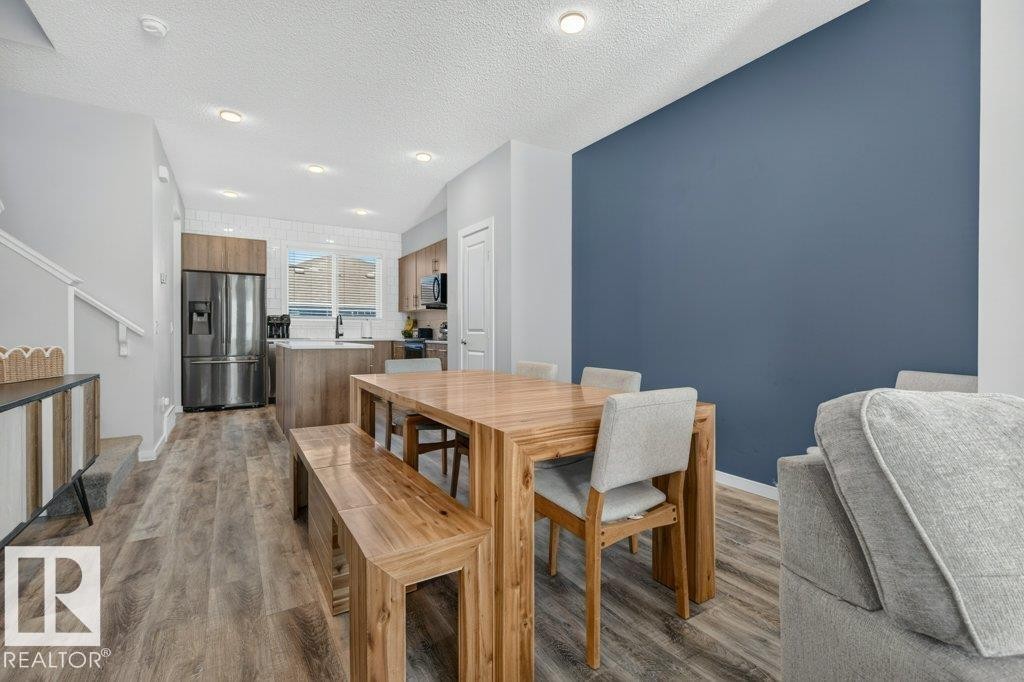 Open-concept living space with wood-finish flooring throughout - 2116 Maple Road, Edmonton, AB