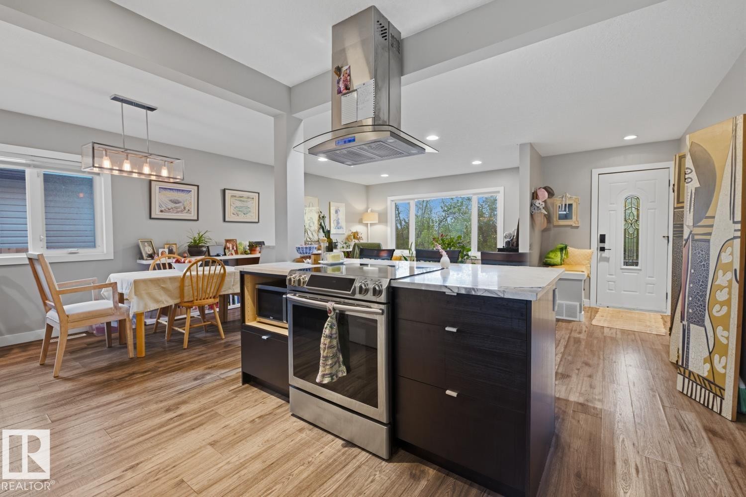 Kitchen island with quartz countertop, stainless steel range and overhead hood fan - 10328 73 Street, Edmonton, AB