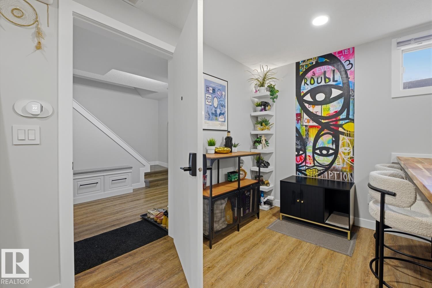 Spacious basement common landing area and suite entrance featuring vinyl plank flooring and LED lighting throughout - 10328 73 Street, Edmonton, AB