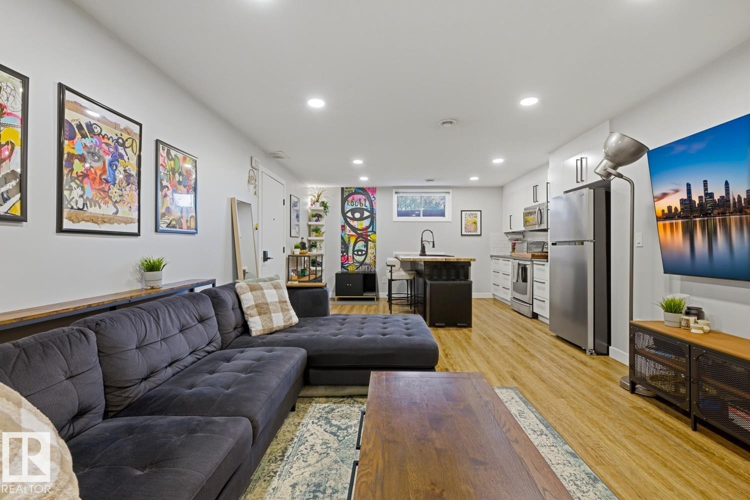Open-concept living space featuring recessed LED lighting and vinyl plank flooring throughout - 10328 73 Street, Edmonton, AB