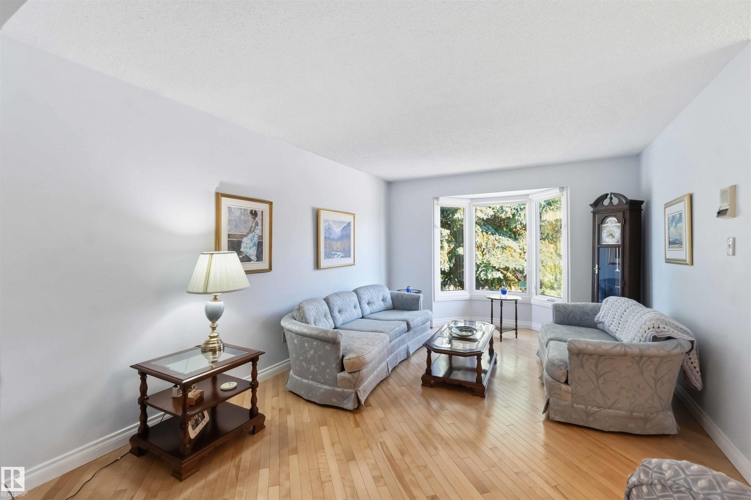 Bright living area featuring light-toned walls and wood-finish flooring - 31 Gariepy Crescent, Edmonton, AB